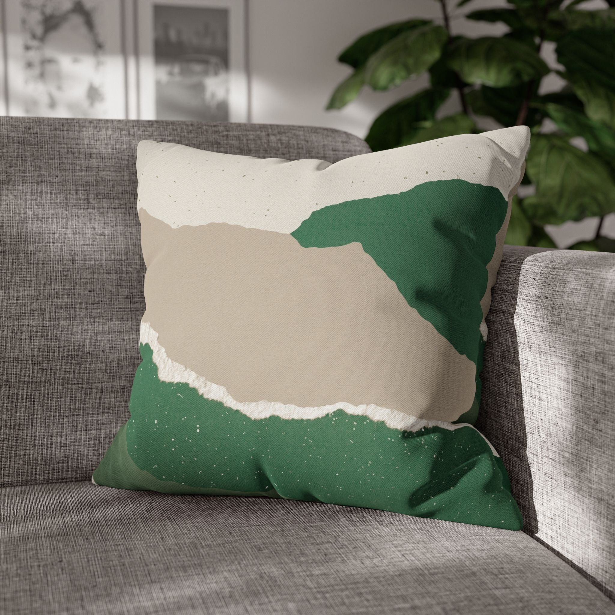 A gray couch with a green and beige throw pillow featuring a geometric pattern.