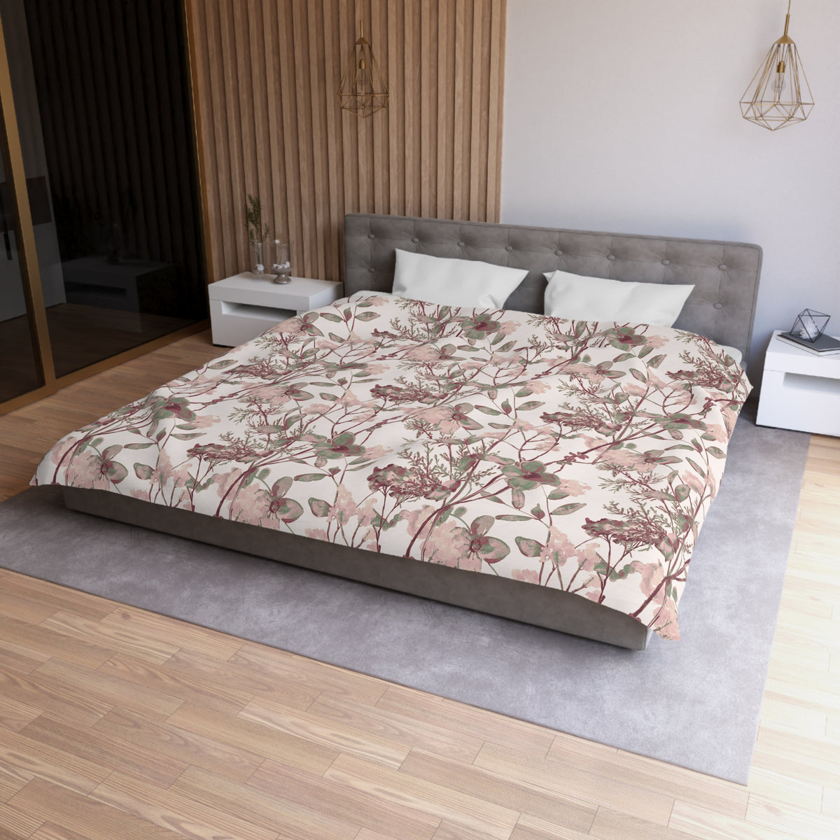 a modern bedroom with a large bed, a gray headboard, and a floral patterned comforter. The room has a wooden floor and white walls, creating a serene and elegant atmosphere.