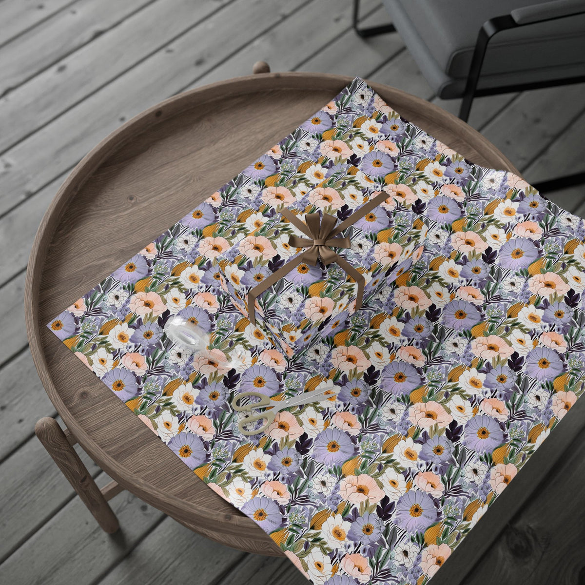Gift wrapped in lilac and peach garden blossom wrapping paper with a roll on a round wooden side table