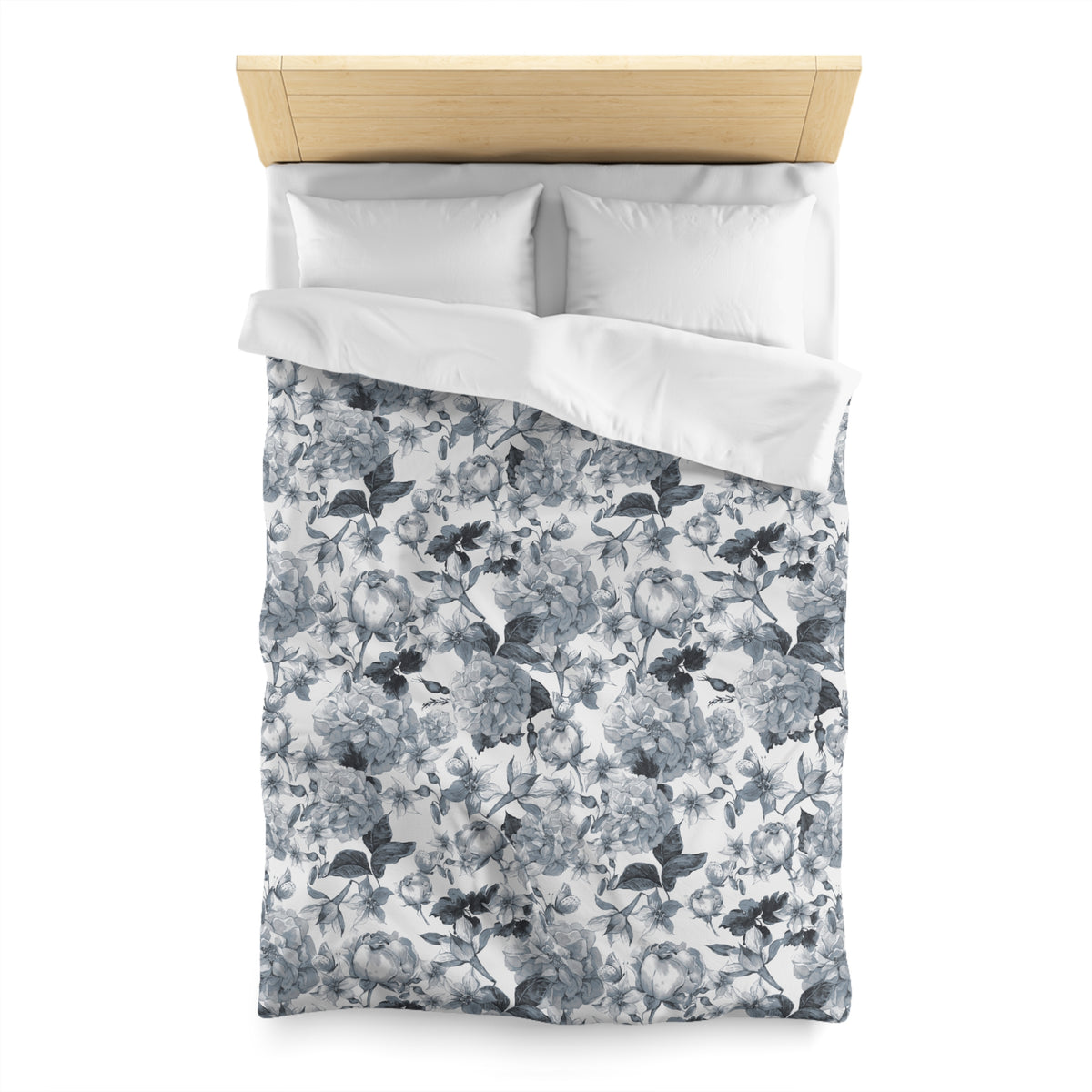 a neatly made bed with a floral print duvet cover and two white pillows.