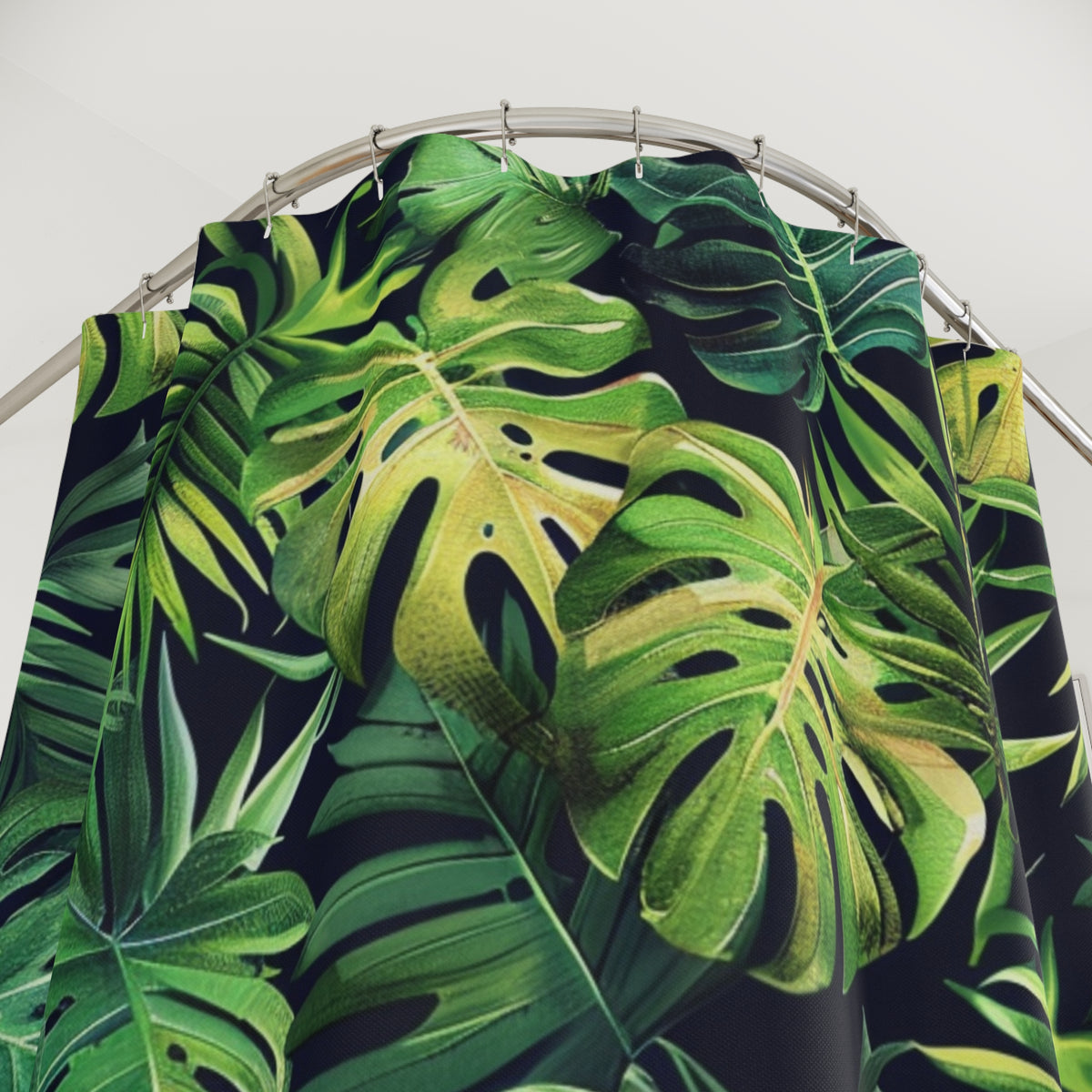 a shower curtain with a tropical leaf pattern in shades of green and yellow.