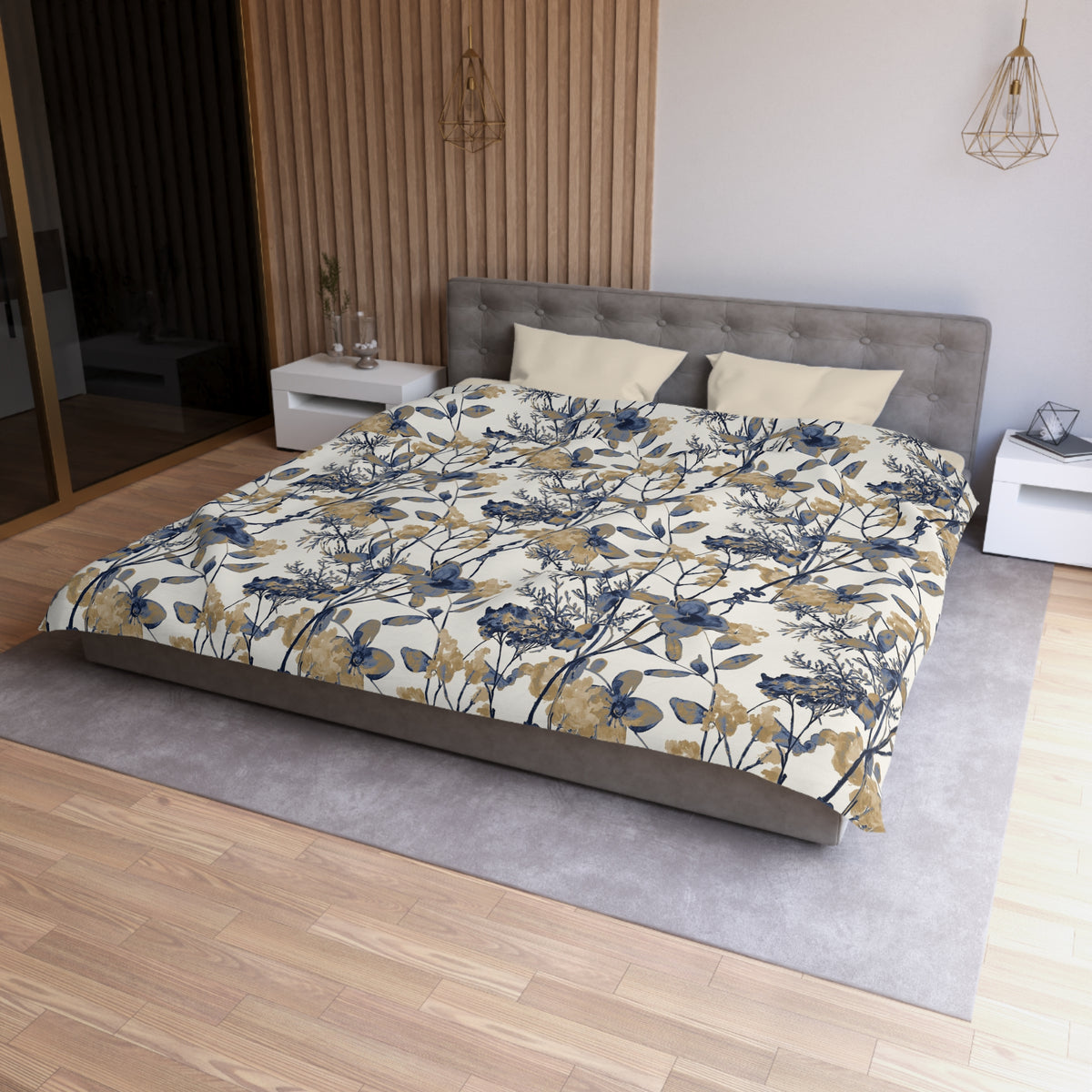 a modern bedroom with a large bed, a gray headboard, and a floral patterned comforter. The room has a wooden floor and white walls, creating a serene and elegant atmosphere.