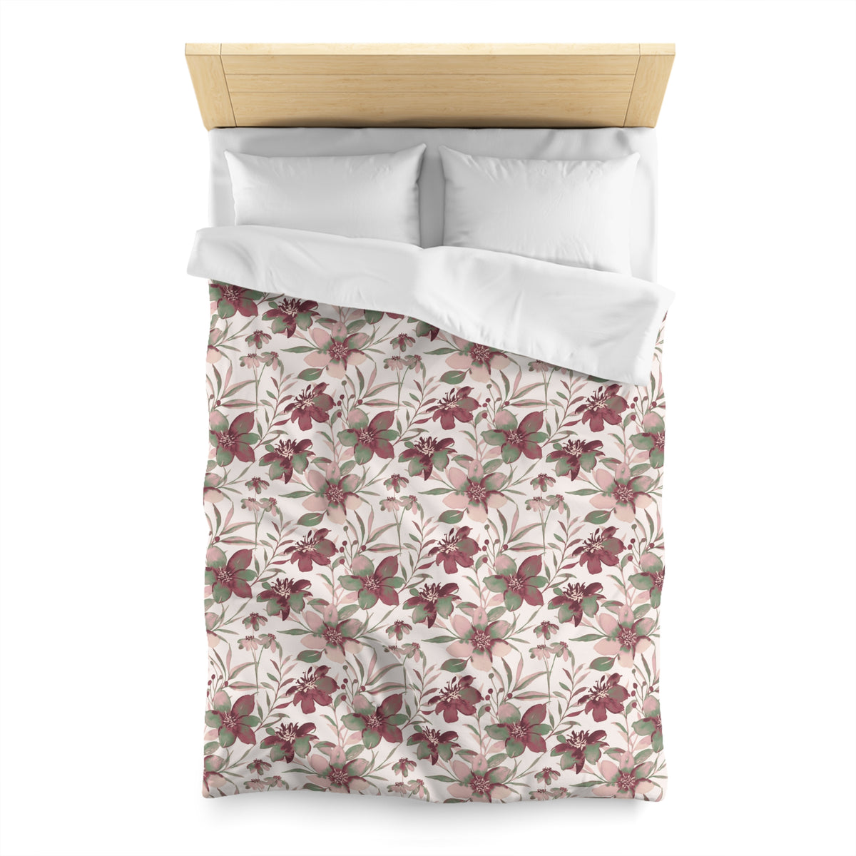 a neatly made bed with a floral print duvet cover and two white pillows.
