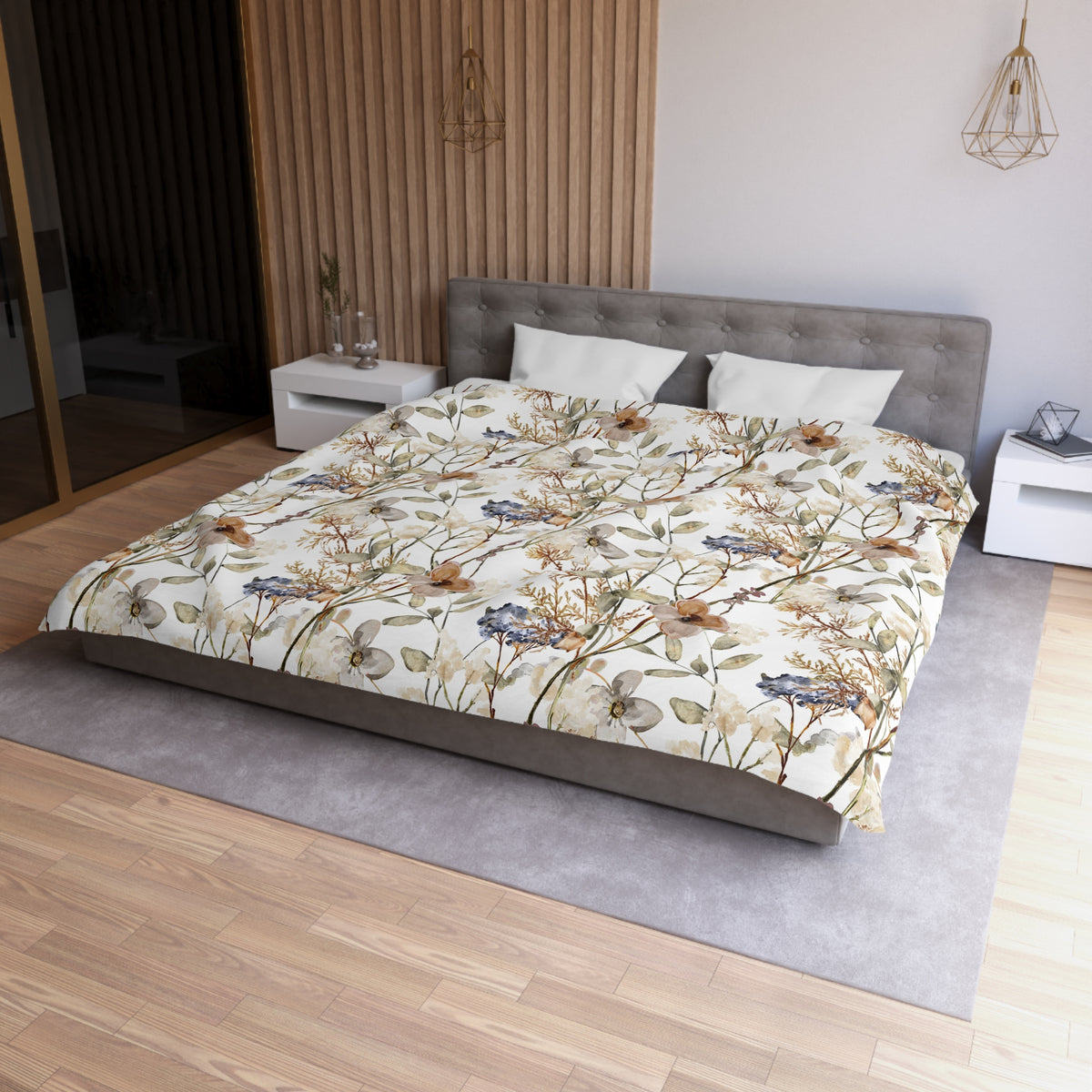 a modern bedroom with a large bed, a gray headboard, and a floral print comforter. The room has a wooden floor and white walls, creating a serene and elegant atmosphere.