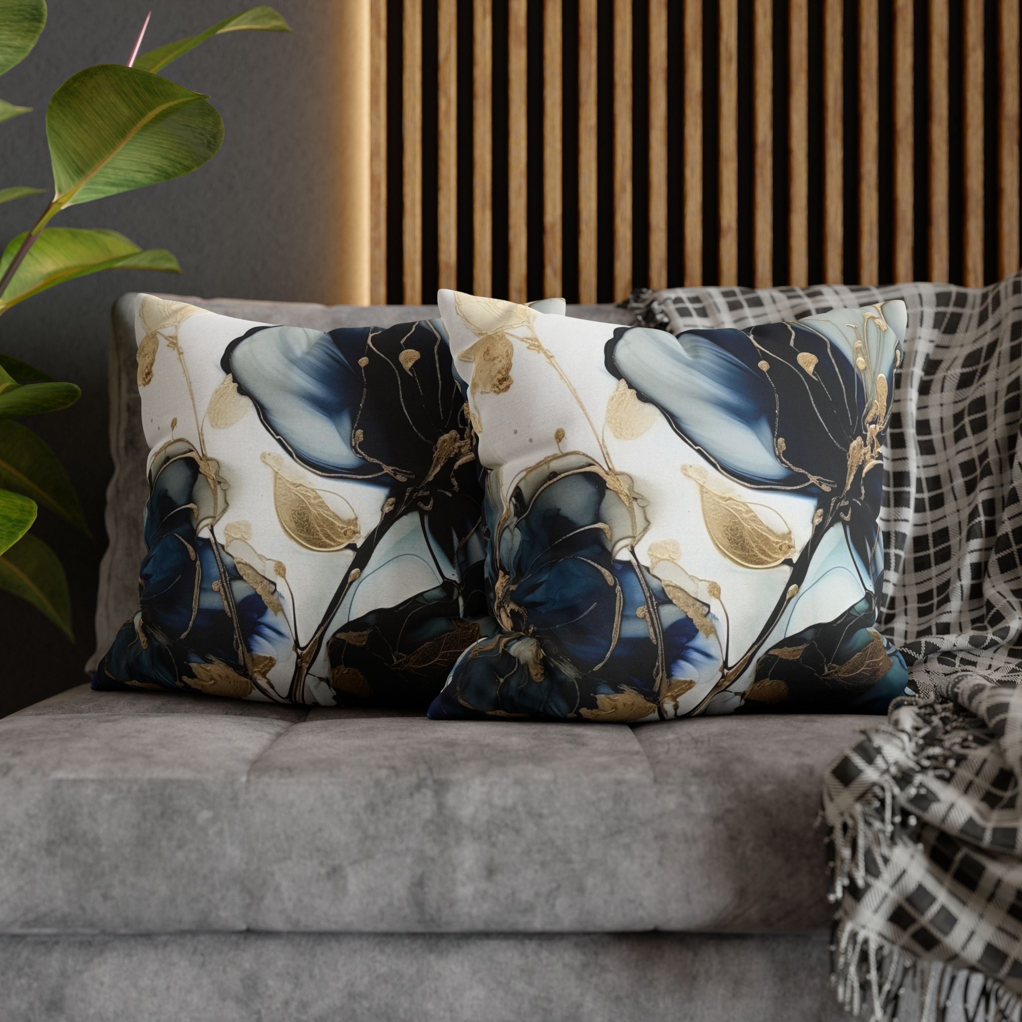 a gray sofa with two decorative throw pillows on it. The pillows have a floral pattern in shades of blue and gold.