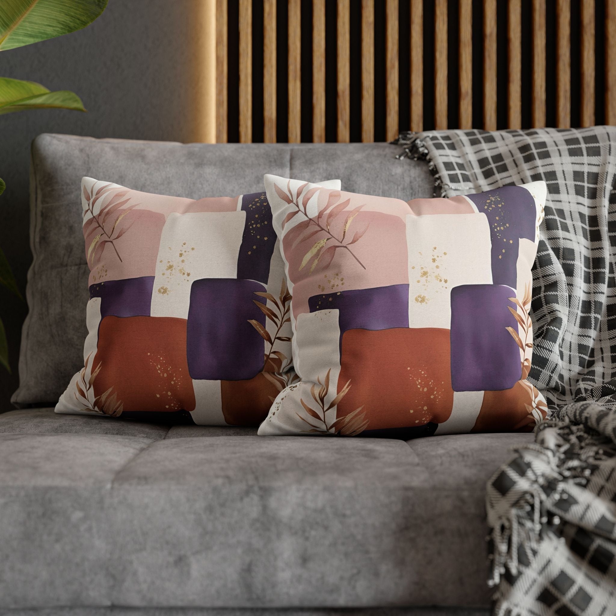a gray couch with two decorative throw pillows on it. The pillows have a colorful abstract pattern with shades of pink, purple, and orange.