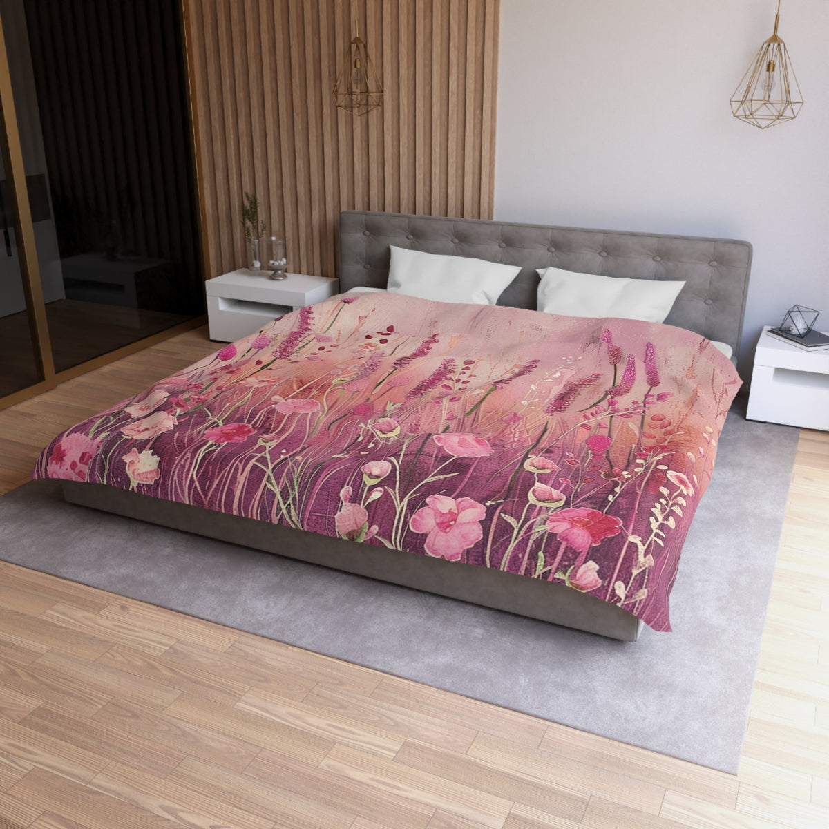 a bedroom with a large bed covered in a floral print blanket. The bed is positioned against a wall with a wooden panel. The room has a modern and minimalist design, with a gray headboard and white nightstands.