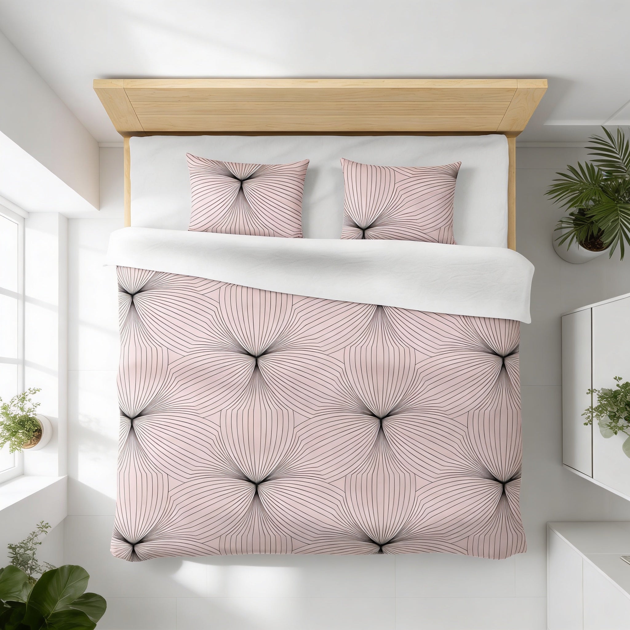 a bedroom with a bed covered in a pink and black geometric patterned comforter and pillows. The bed is positioned against a white wall, with a window and two potted plants nearby.
