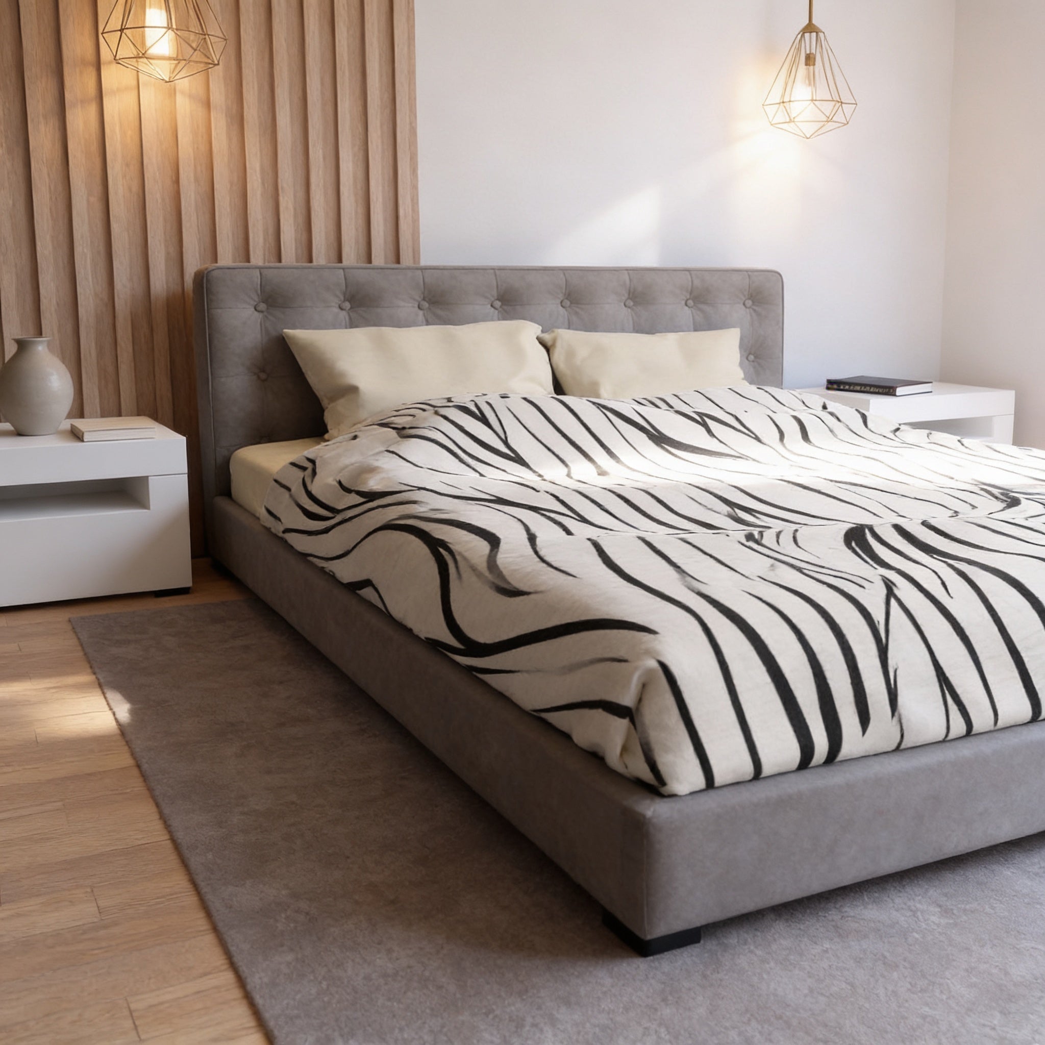 a modern bedroom with a gray tufted headboard, a black and white zebra-patterned comforter, and a wooden wall with a light fixture.
