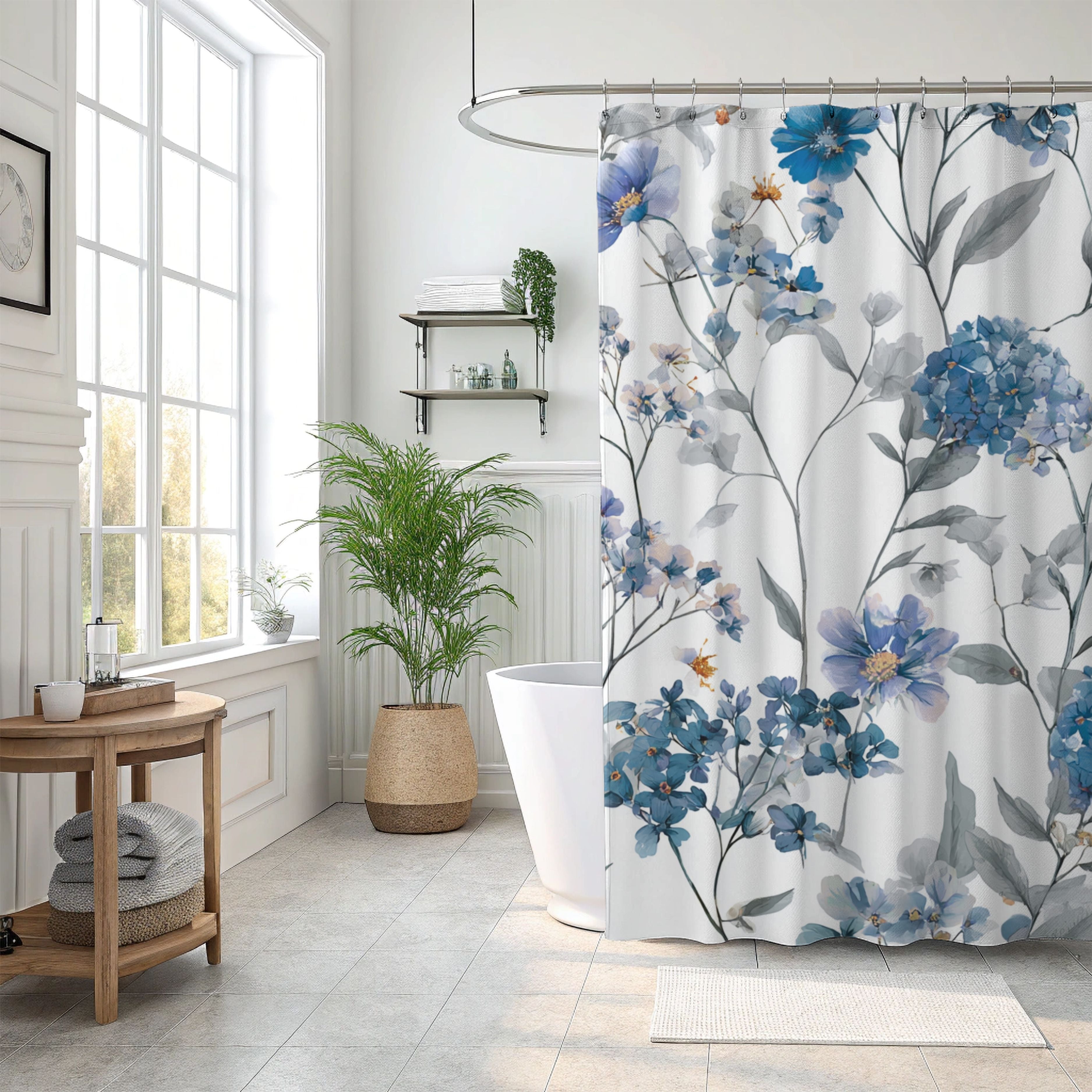 a well-lit bathroom with a floral patterned shower curtain, a wooden side table, a potted plant, and a white bathtub.