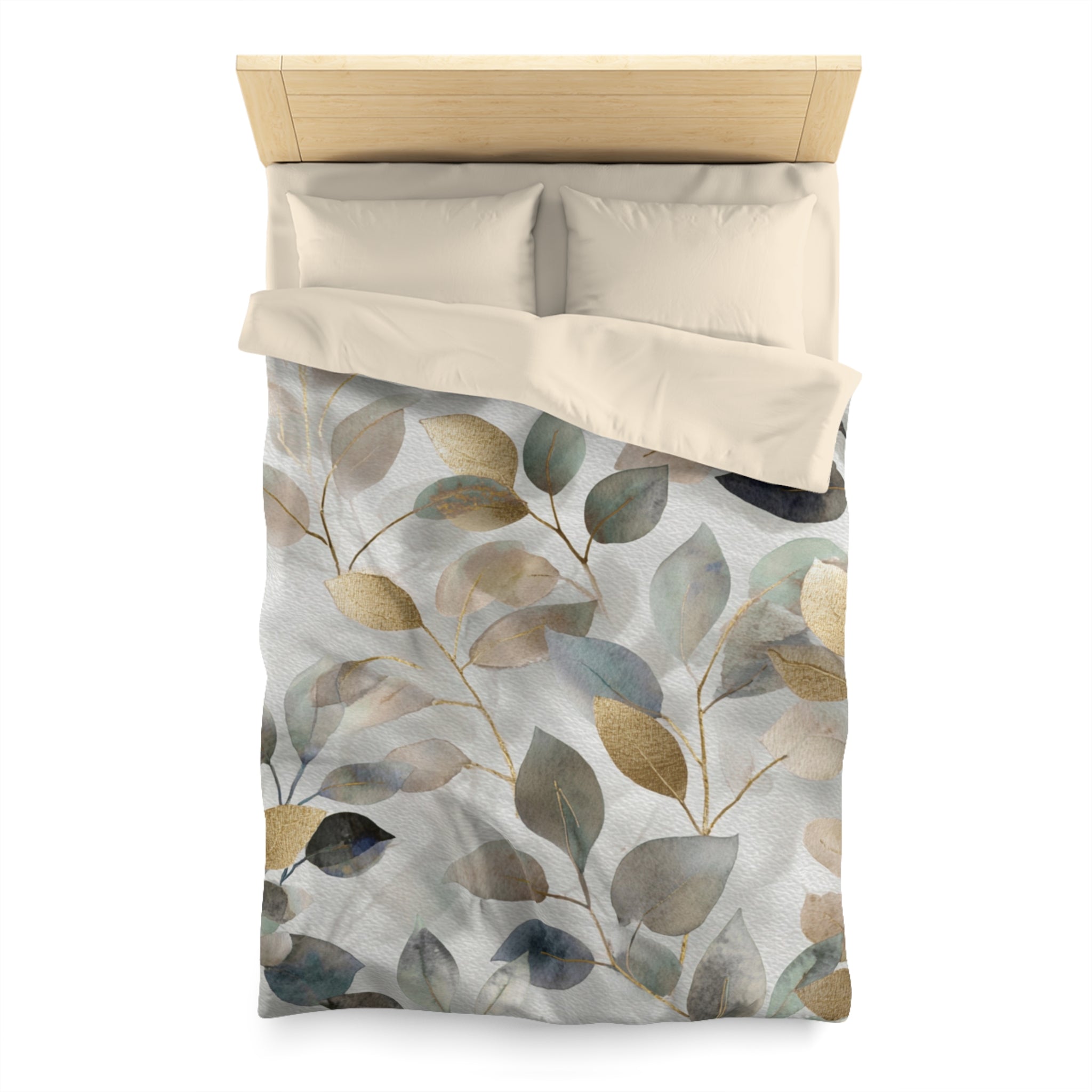 a bed with a white comforter and a decorative leaf pattern on it.