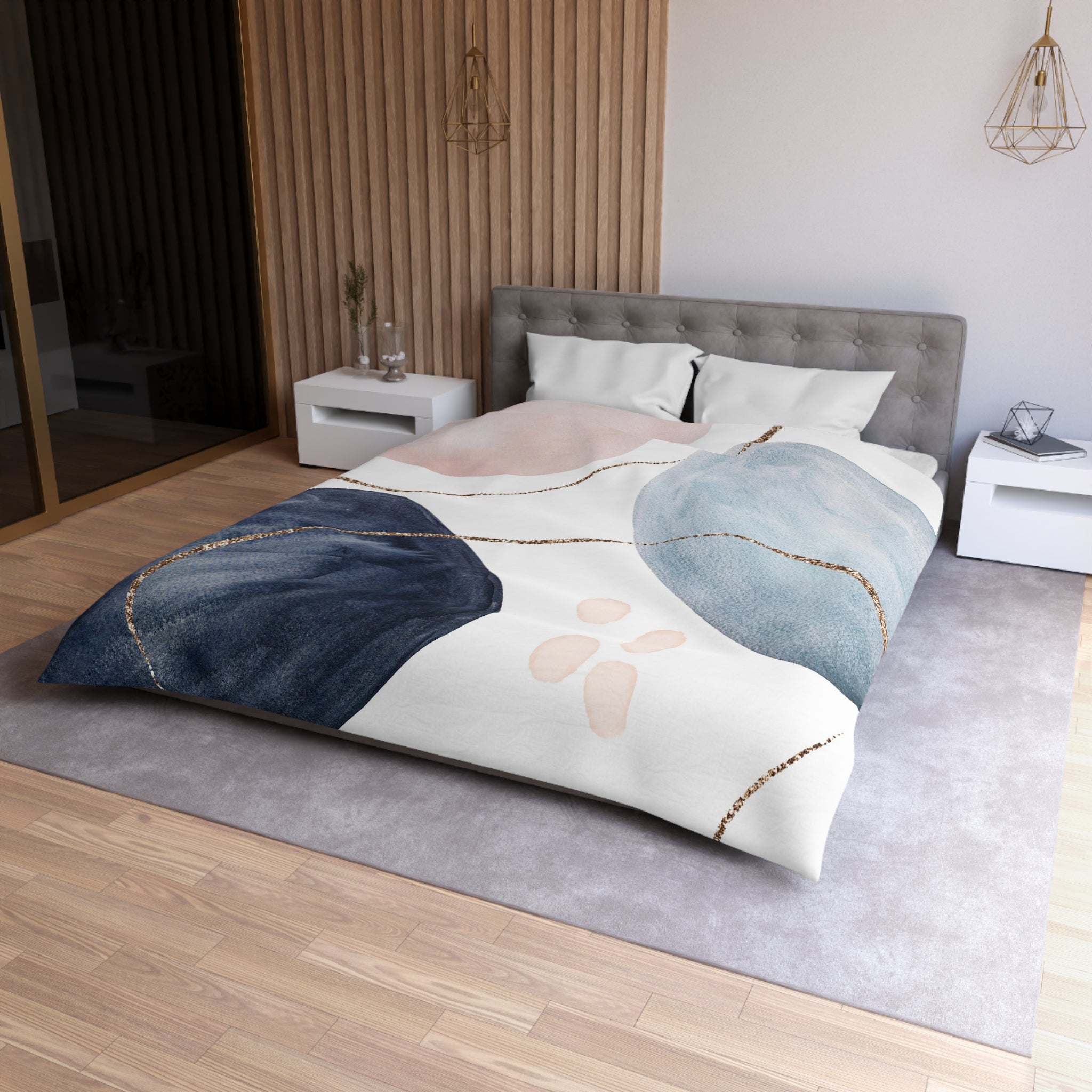 a modern bedroom with a large bed, a gray headboard, and a colorful abstract patterned comforter. The room has a wooden floor and white walls, creating a clean and minimalist aesthetic.