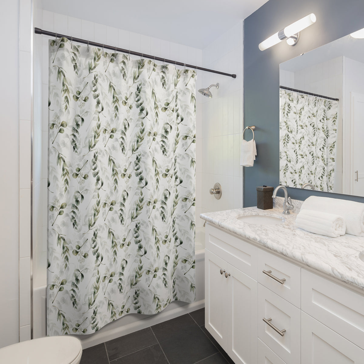 a modern bathroom with a white vanity, a shower curtain with a leaf pattern, and a mirror above the sink.