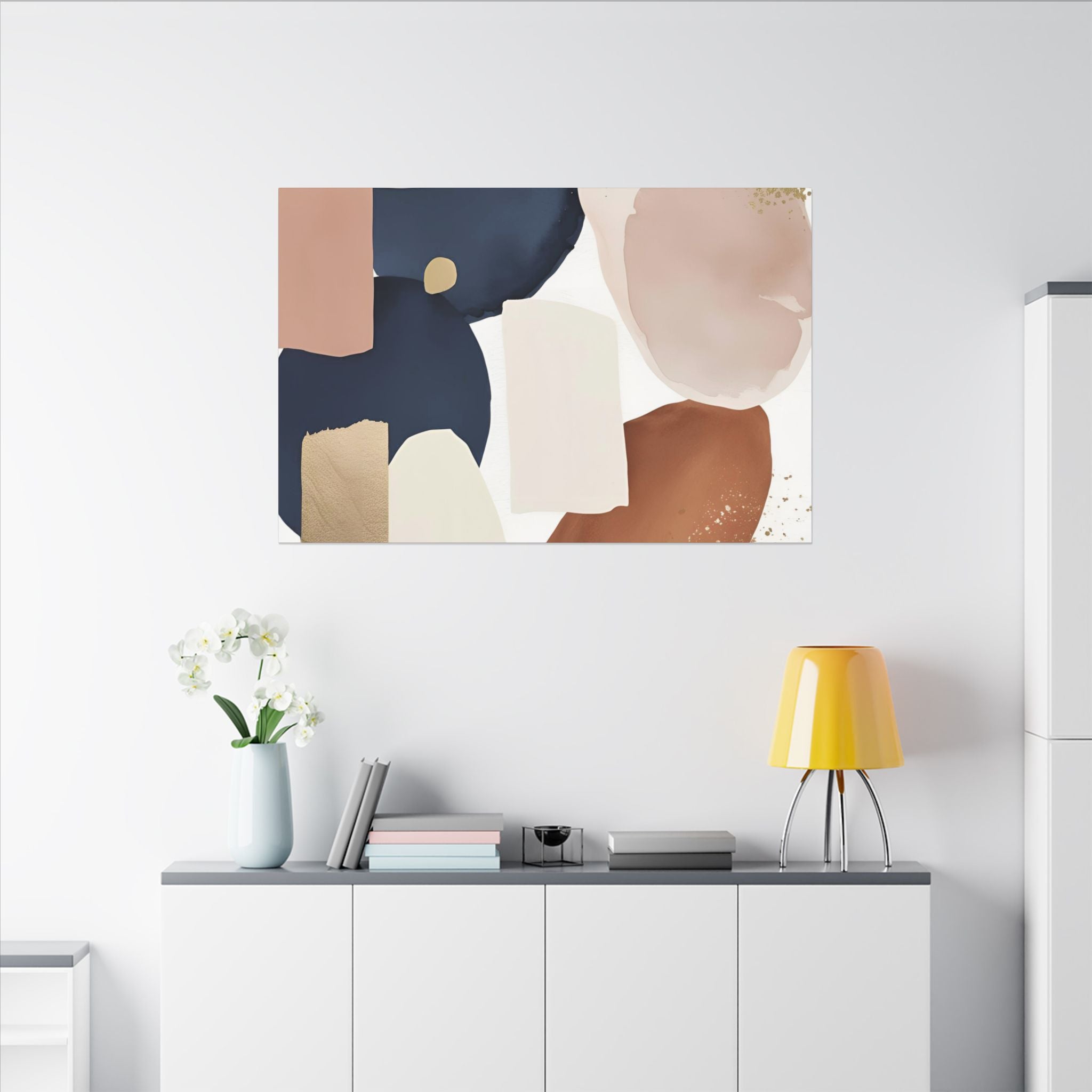 a minimalist living space with a white wall, a white cabinet, and a painting hanging above it. The painting is abstract and colorful, with various shades of blue, pink, and brown. There are also some decorative elements in the room, such as a vase with white flowers and a yellow lamp on a white shelf.