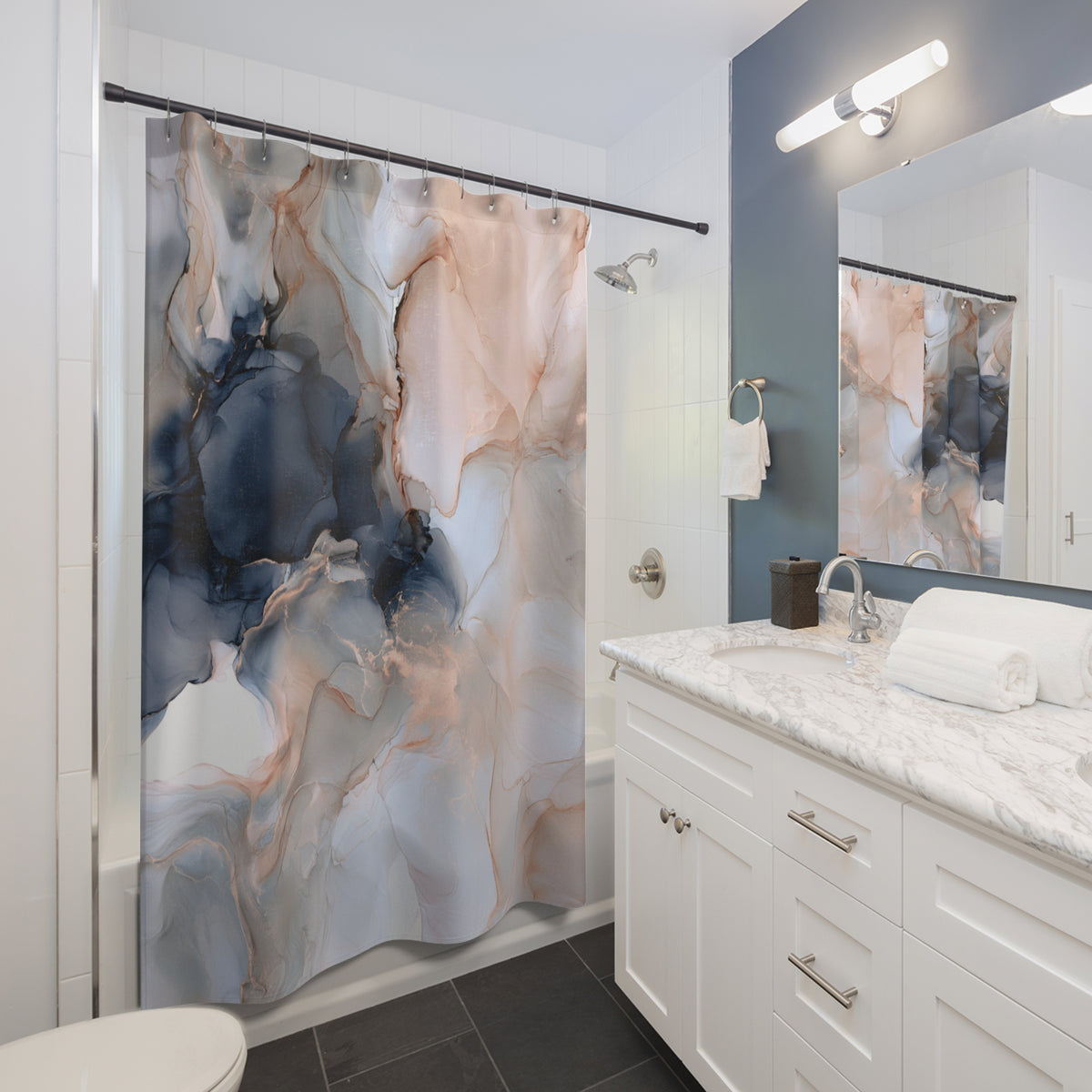 a modern bathroom with a white vanity, marble countertop, and a shower curtain with a marble and blue abstract design.