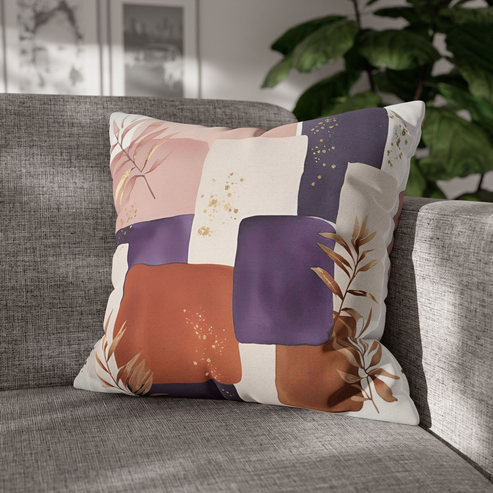 A decorative throw pillow with a colorful abstract pattern sits on a gray couch, with a plant visible in the background.