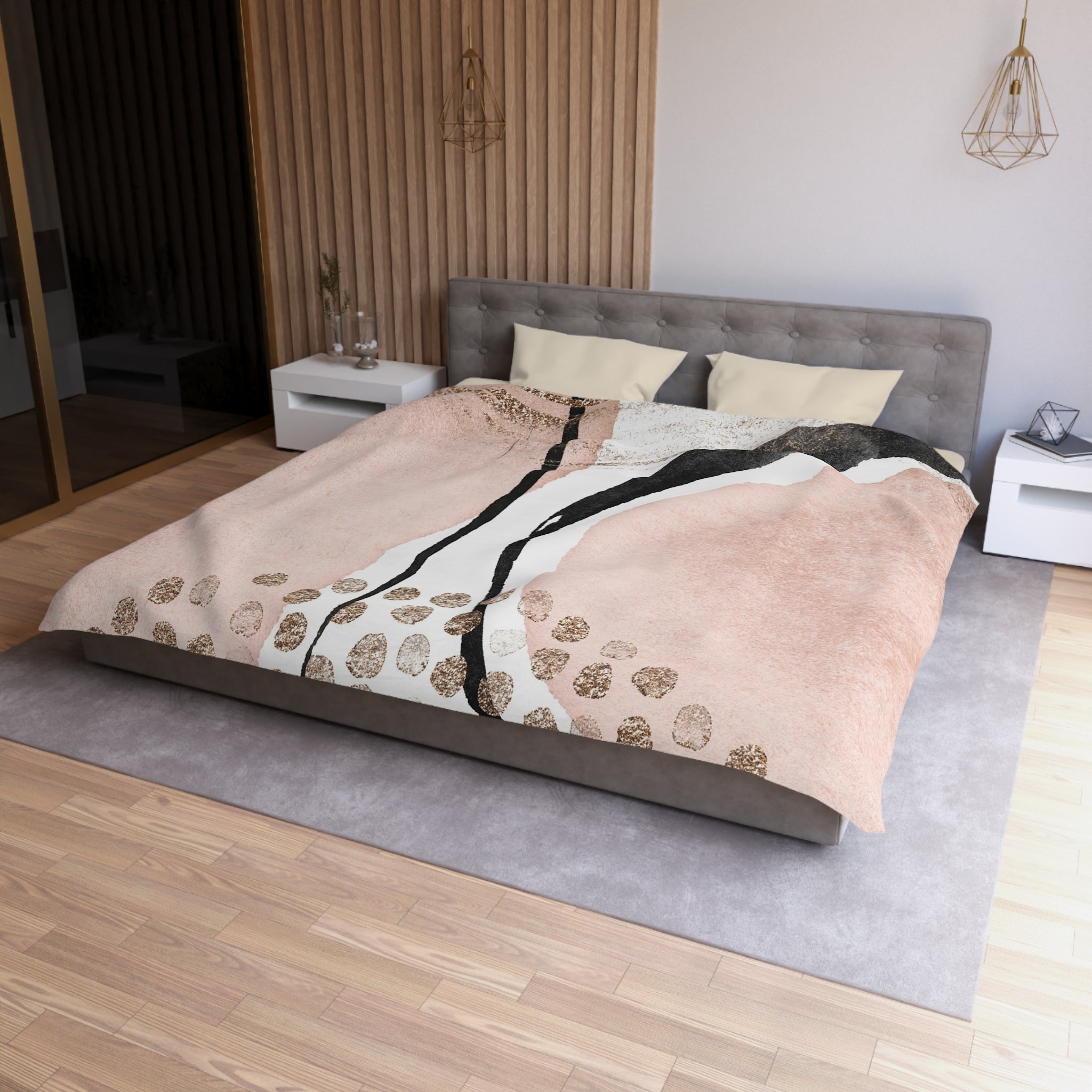 a modern bedroom with a large bed, a gray headboard, and a wooden floor. The bed is covered with a pink and white patterned comforter, and there are two pillows on the bed. The room also features a nightstand, a pendant light, and a mirror.