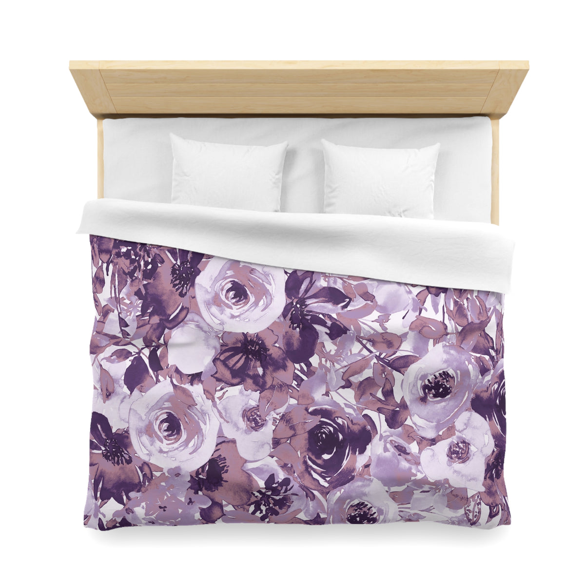 a bed with a floral print duvet cover featuring purple and white flowers. The duvet cover is spread out on the bed, and there are two pillows on the bed.