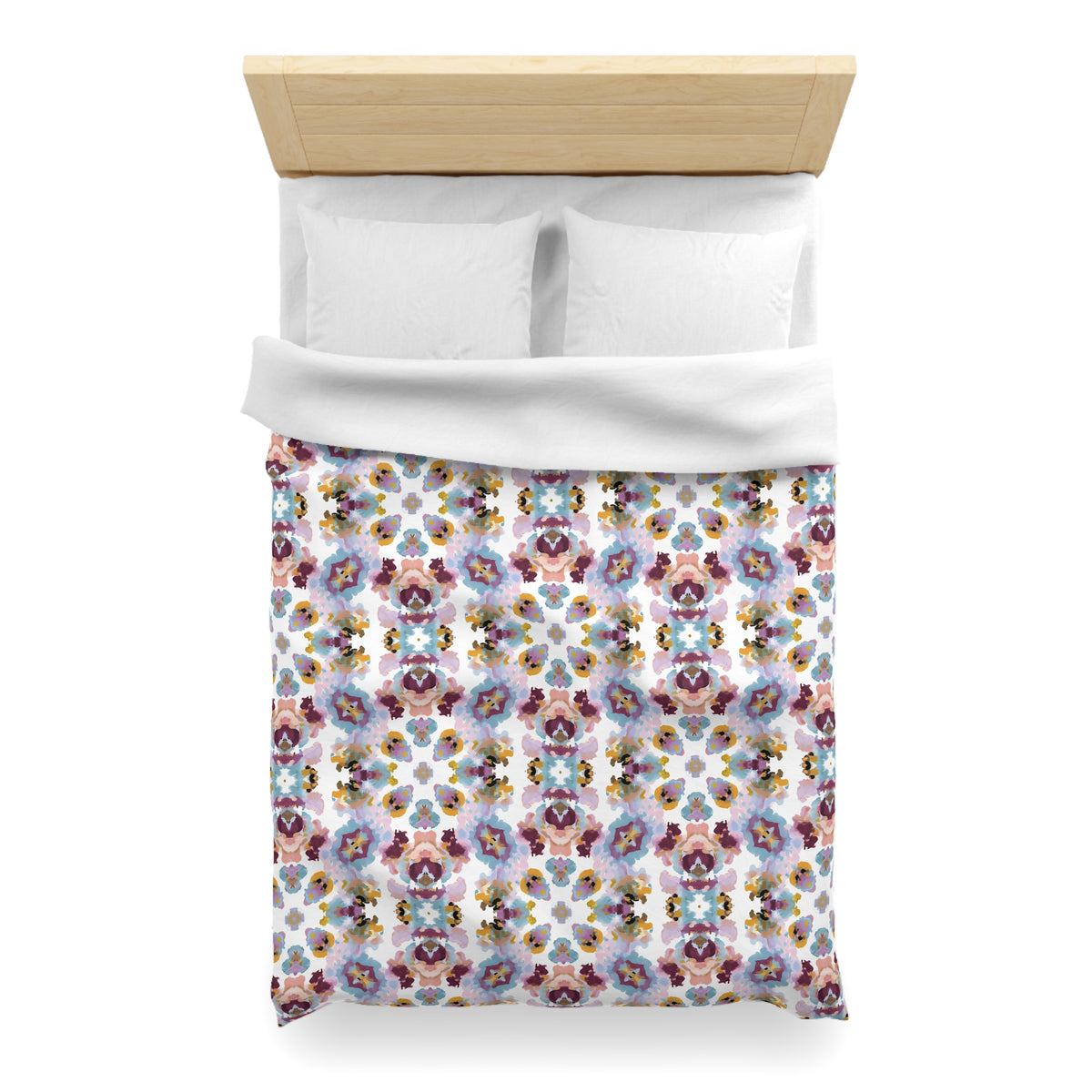 a neatly made bed with a colorful floral patterned comforter and pillows.