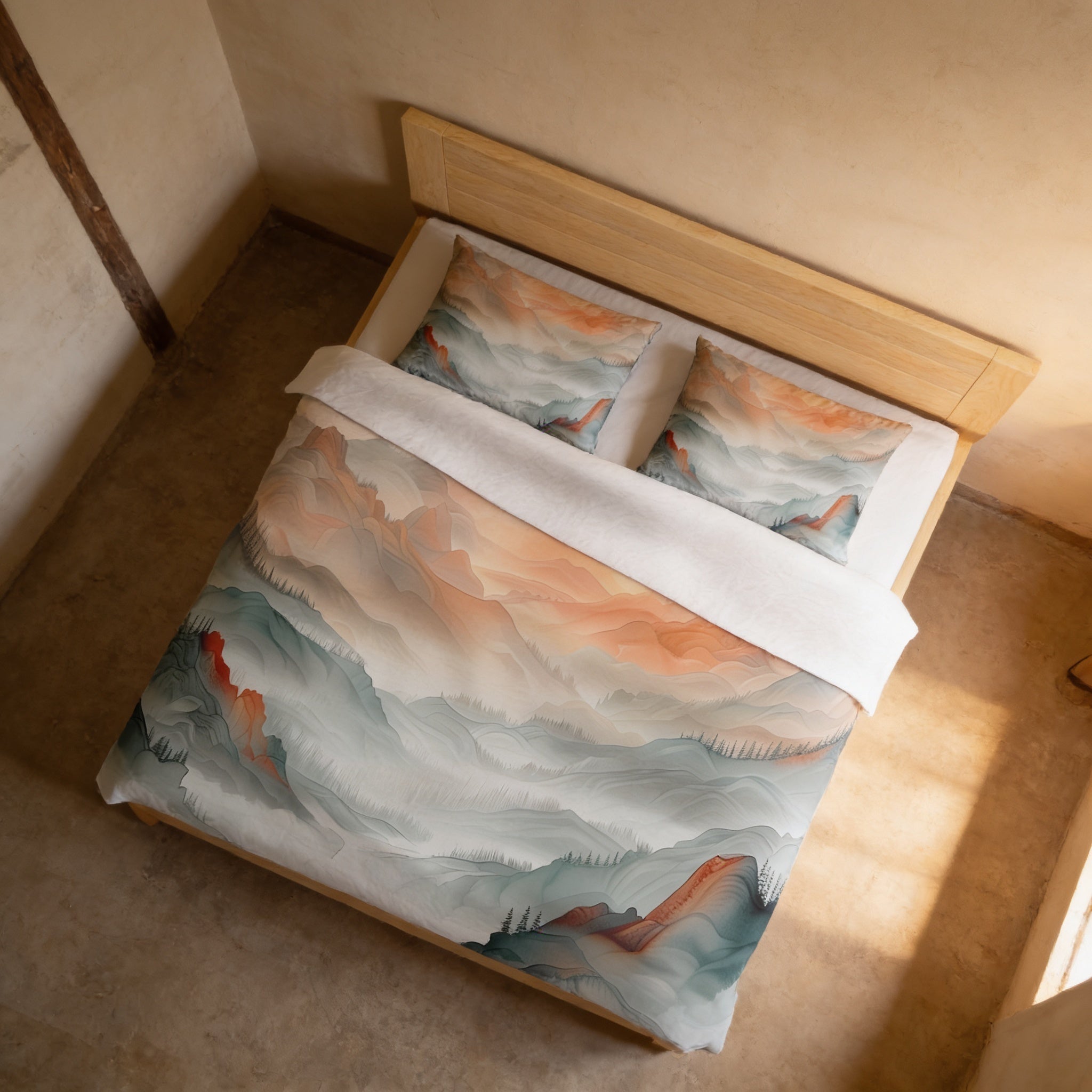 a bed with a colorful mountain landscape printed on the comforter and pillows.