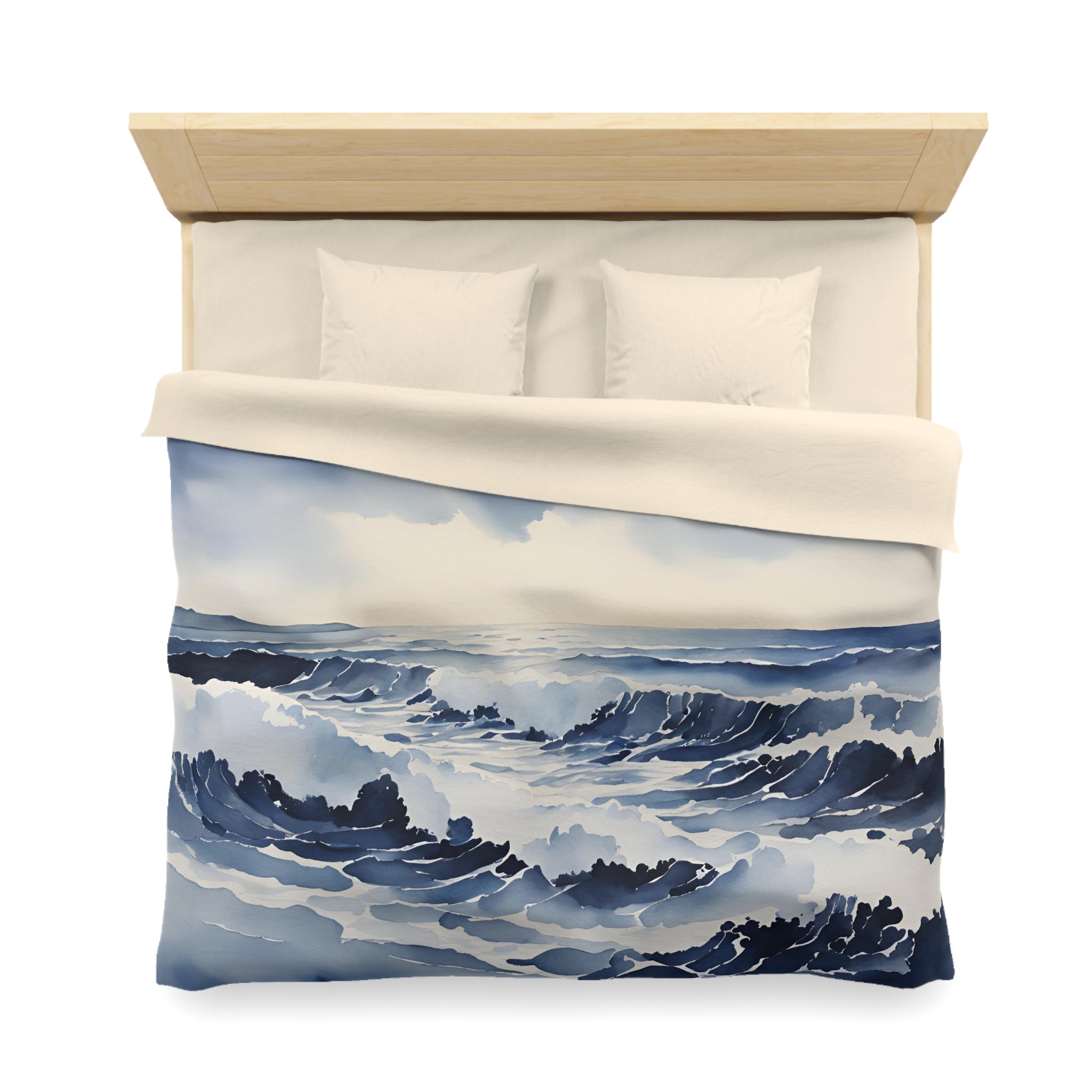 a bed with a blue and white ocean-themed duvet cover featuring a painting of waves crashing on the shore.
