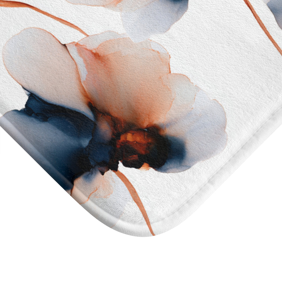 a close-up view of a white bath mat with a striking abstract floral pattern in shades of orange and blue.