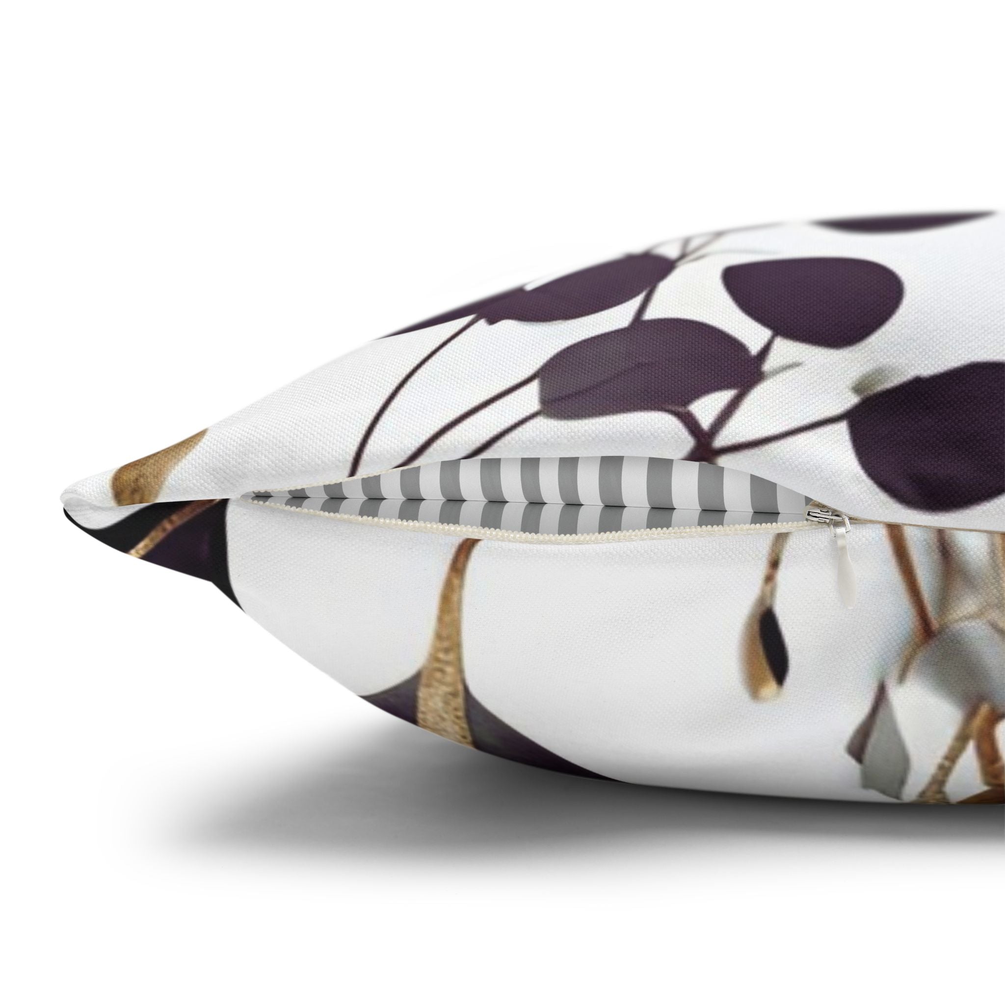 a close-up view of a white pillow with a pattern of purple leaves and gold leaves.