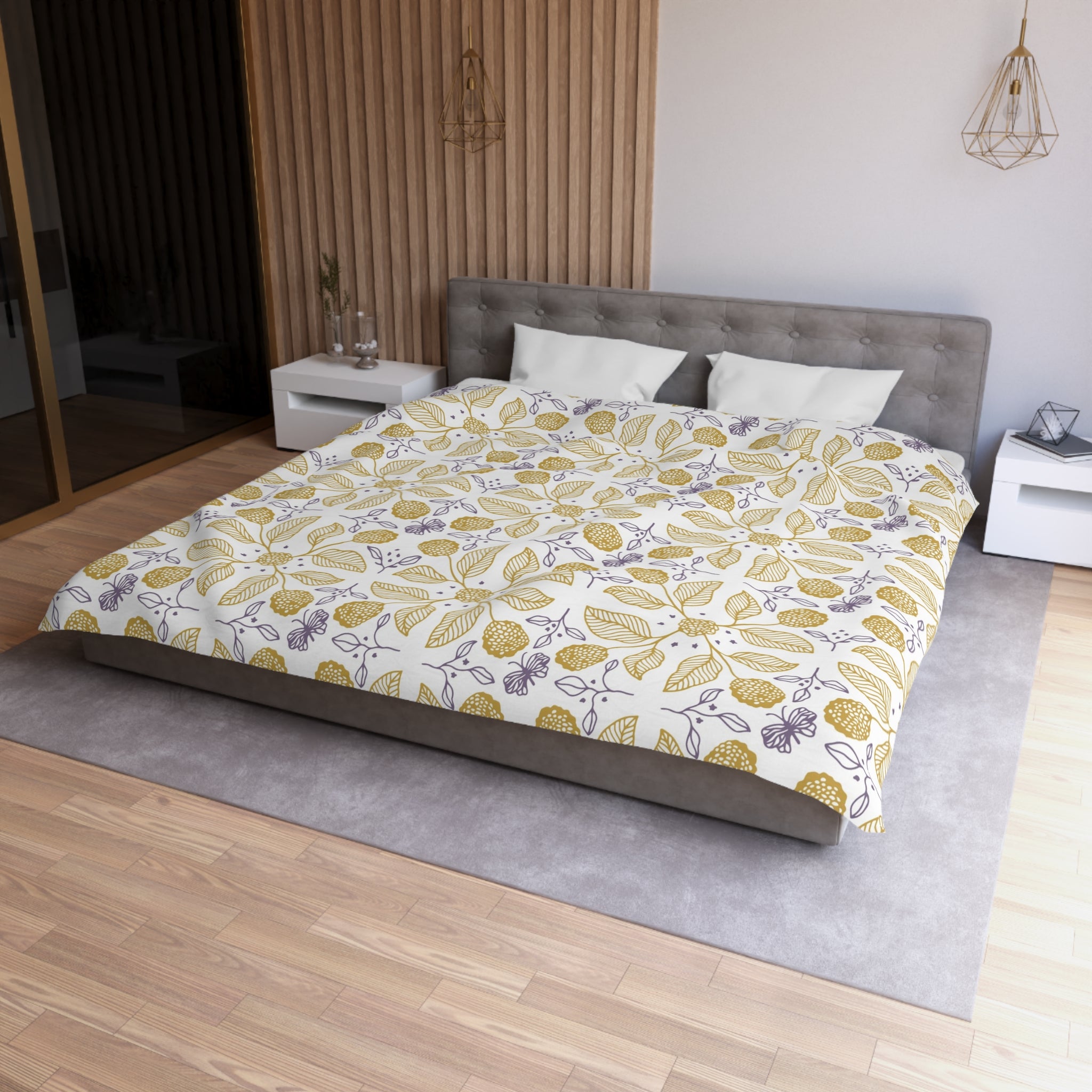 a modern bedroom with a large bed, a gray headboard, and a white nightstand on each side. The bed is covered in a white and yellow floral comforter, and the room has a wooden floor and a gray area rug.