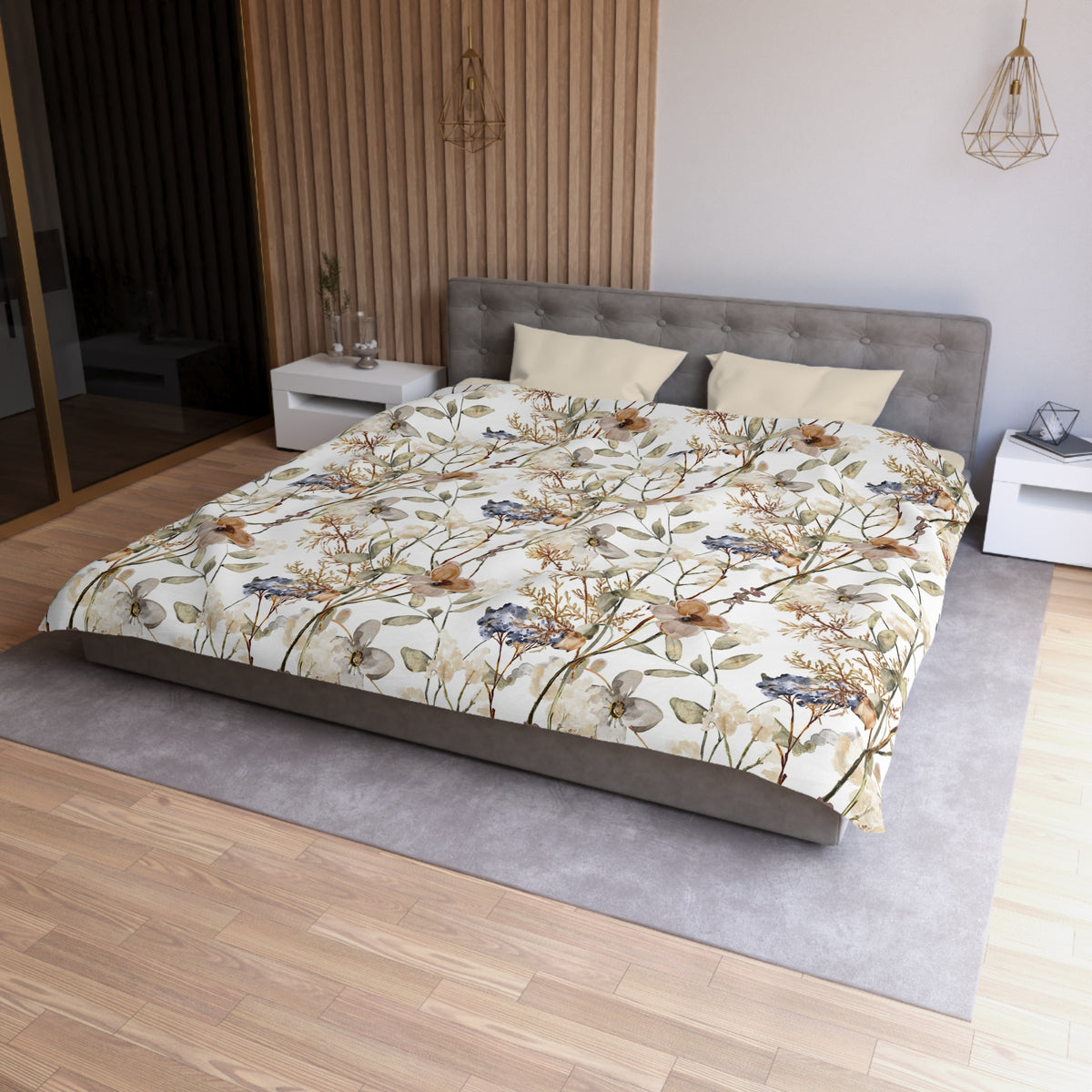 a modern bedroom with a large bed, a gray headboard, and a floral print bedspread. The room has a wooden floor and white walls, creating a serene and elegant atmosphere.