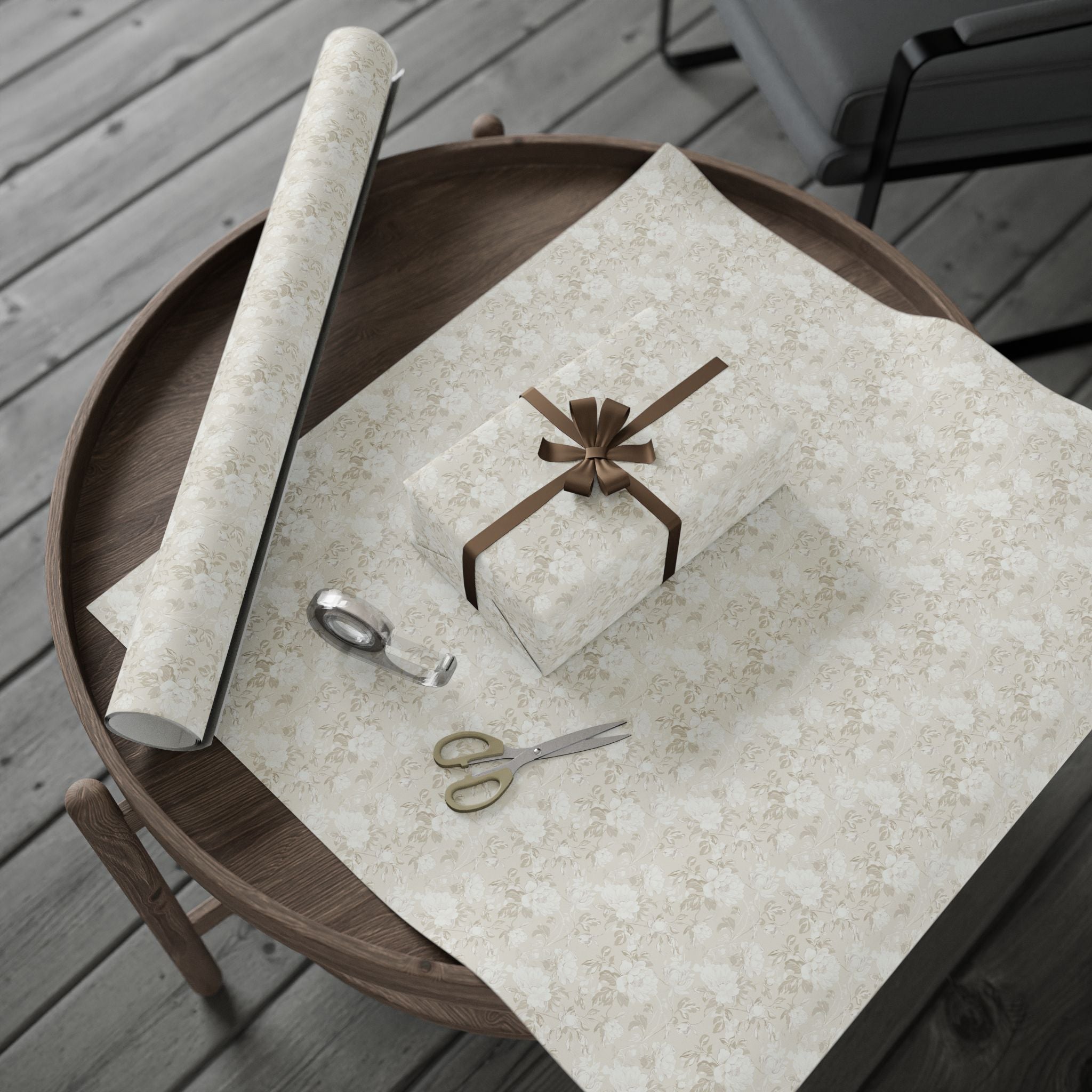 a wooden tray with a roll of wrapping paper, a pair of scissors, and a gift box with a brown bow on a wooden table.