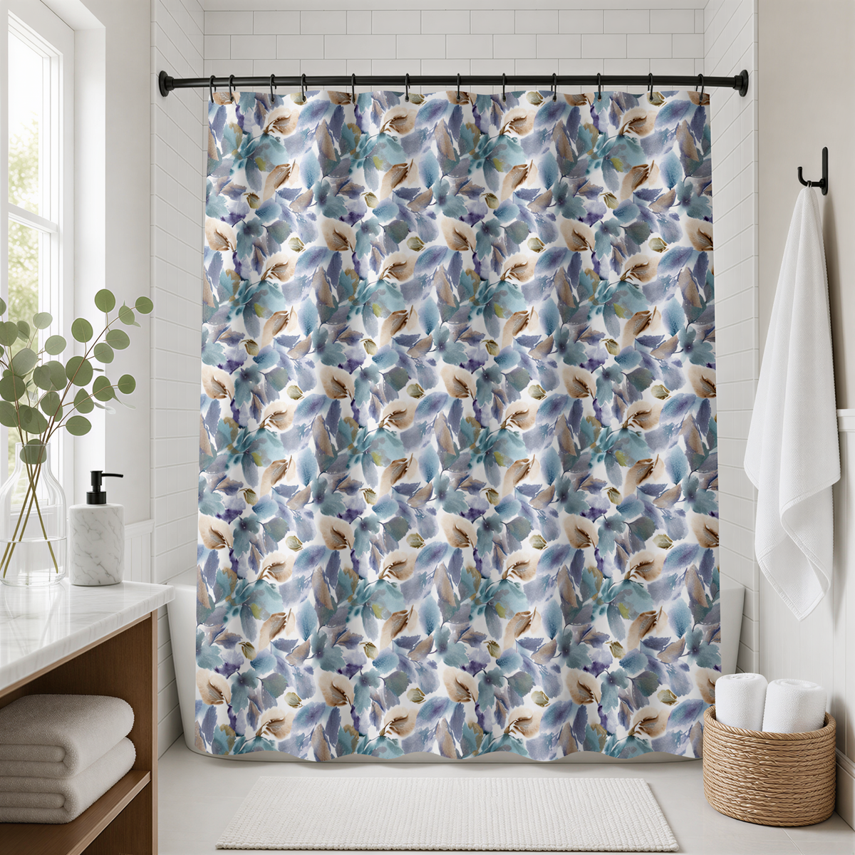 a bathroom with a shower curtain adorned with a blue and green leaf pattern. The shower curtain is hanging from a rod, and there is a basket of towels placed nearby. The bathroom also includes a window, a sink, and a plant, creating a cozy and inviting atmosphere.