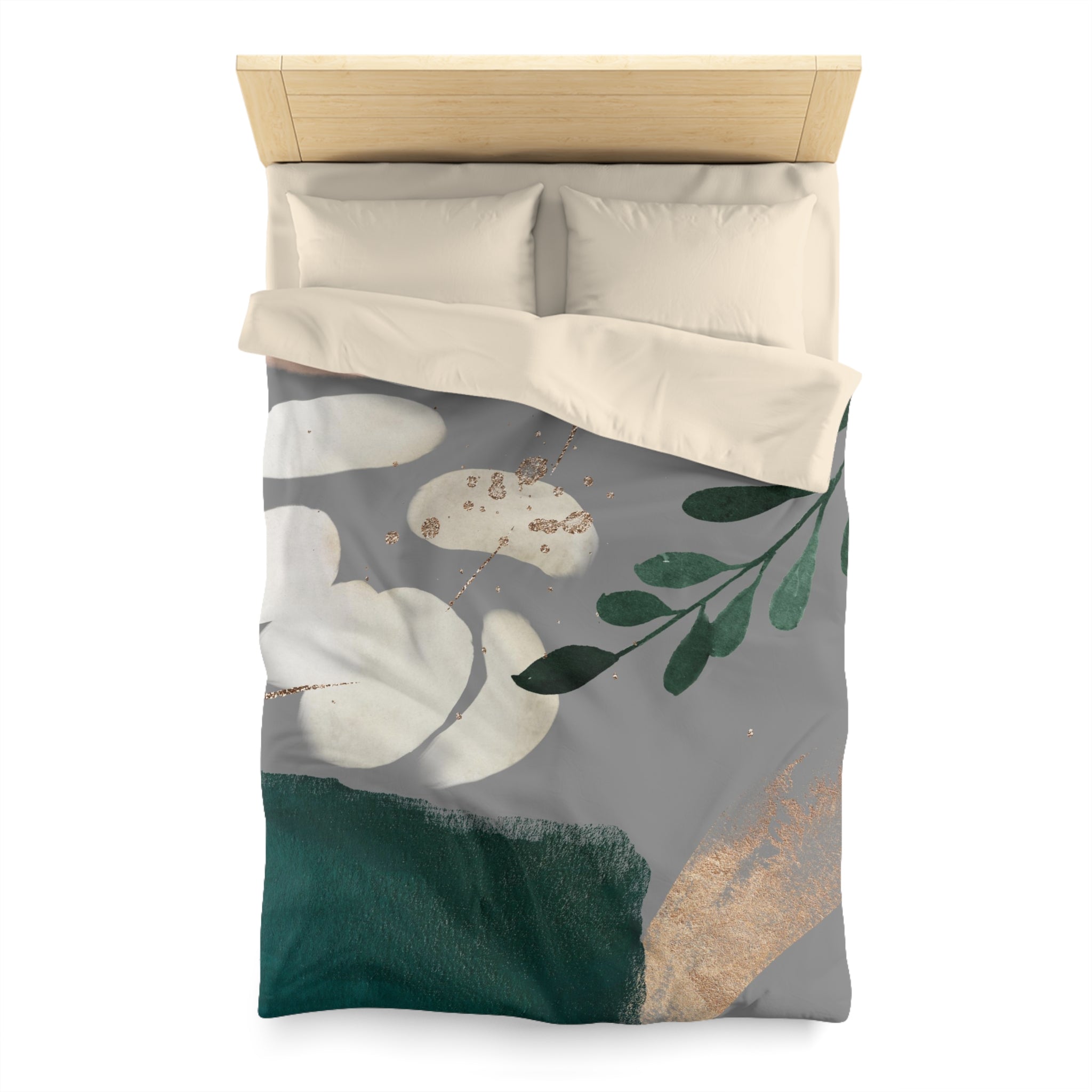 a bed with a gray and green floral print duvet cover and matching pillows.