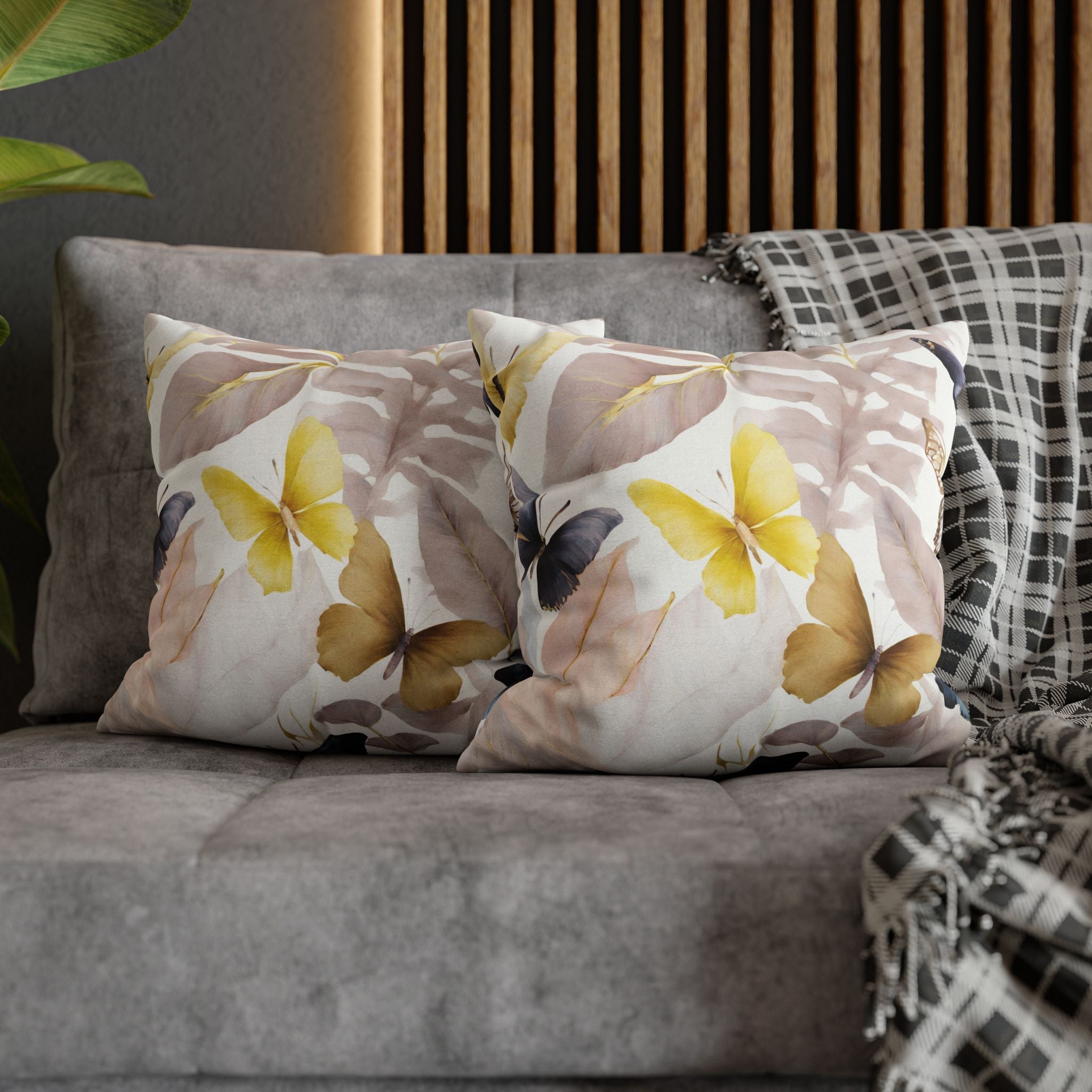 a gray couch with two decorative throw pillows featuring a butterfly and leaf pattern. The pillows are placed on the couch, creating a cozy and inviting atmosphere.