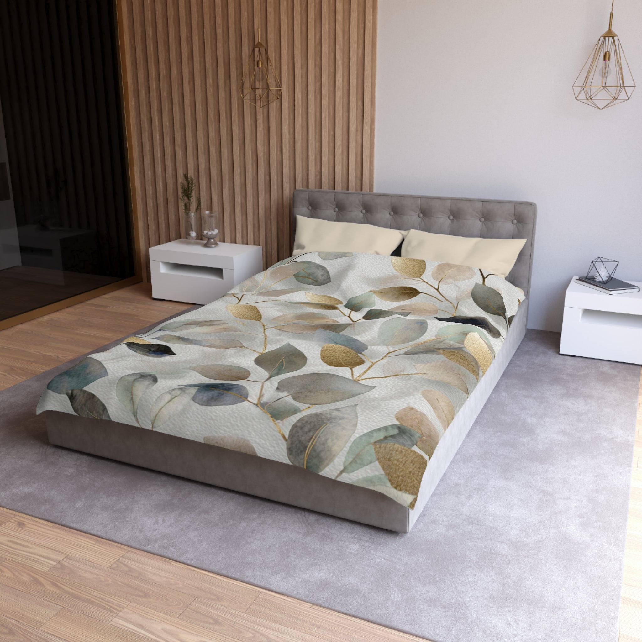a modern bedroom with a gray tufted headboard, a gray bedspread with a leaf pattern, and white nightstands on either side of the bed.