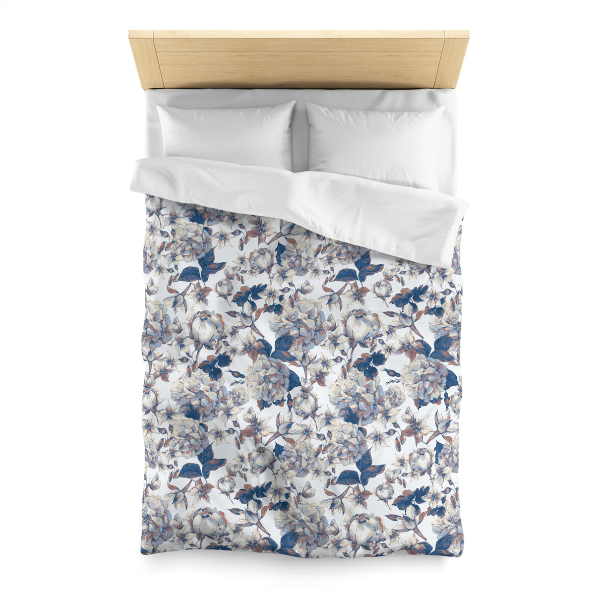 a neatly made bed with a floral patterned comforter and pillows.