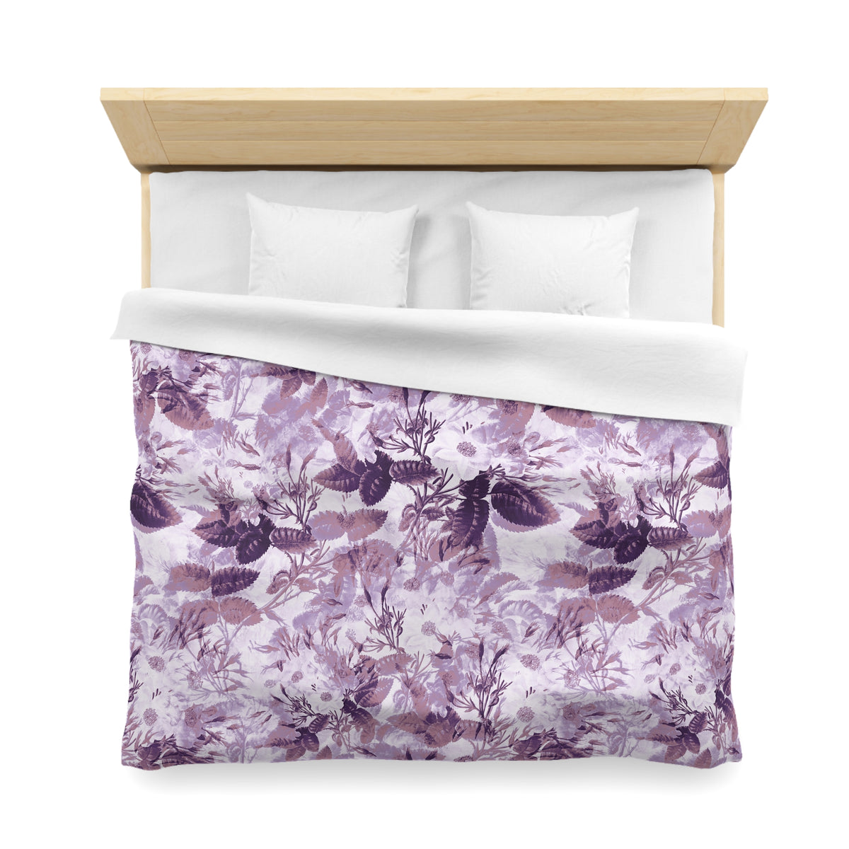 a bed with a floral print duvet cover and white pillows.