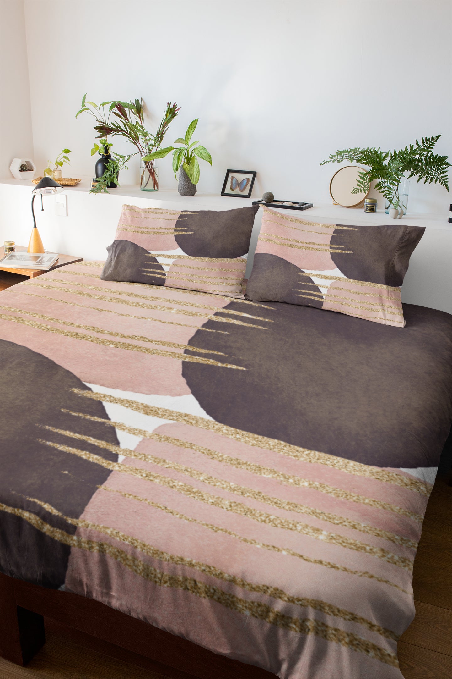 a bed with a pink and brown comforter and pillows