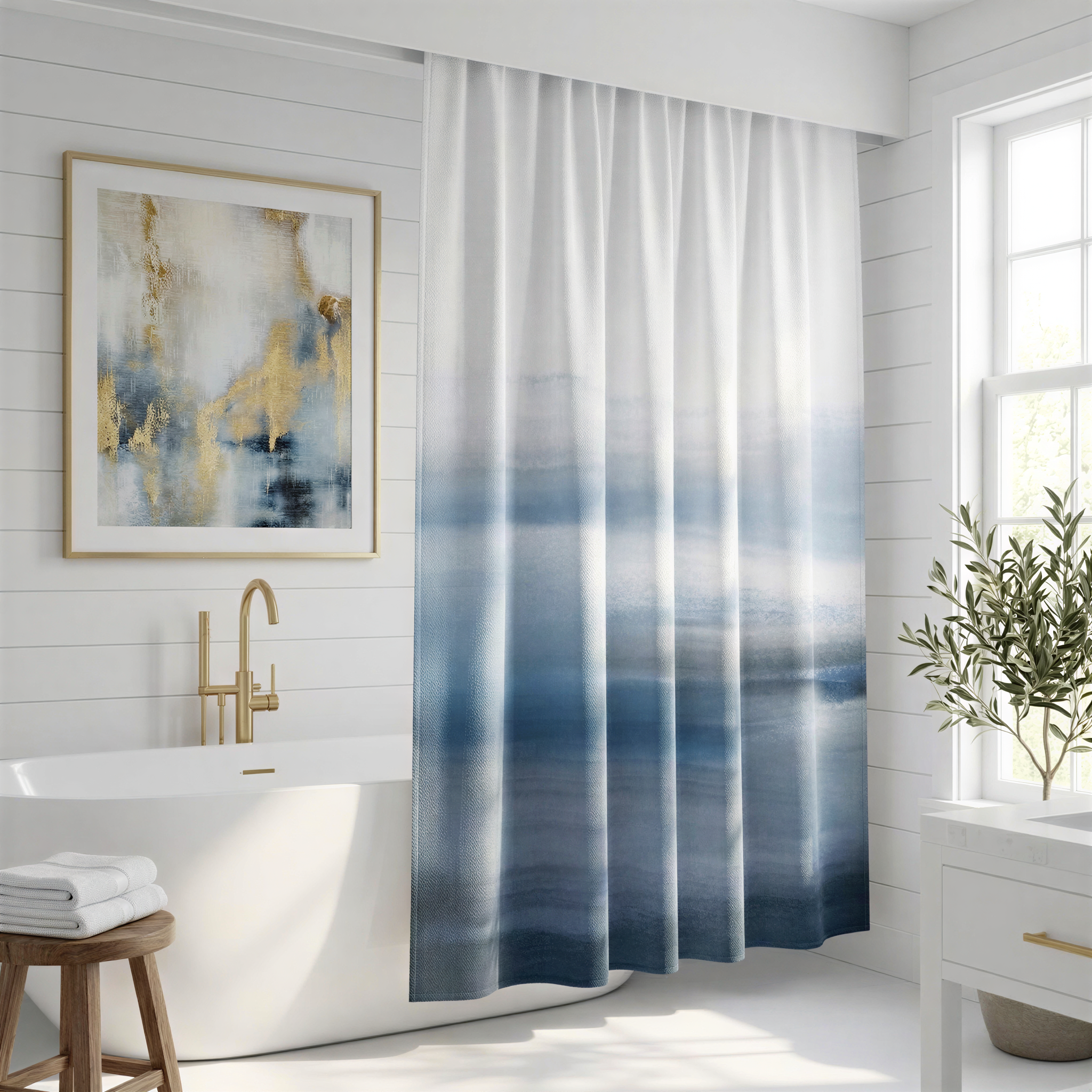 a modern bathroom with a white bathtub, a framed abstract painting on the wall, and a blue and white patterned shower curtain.
