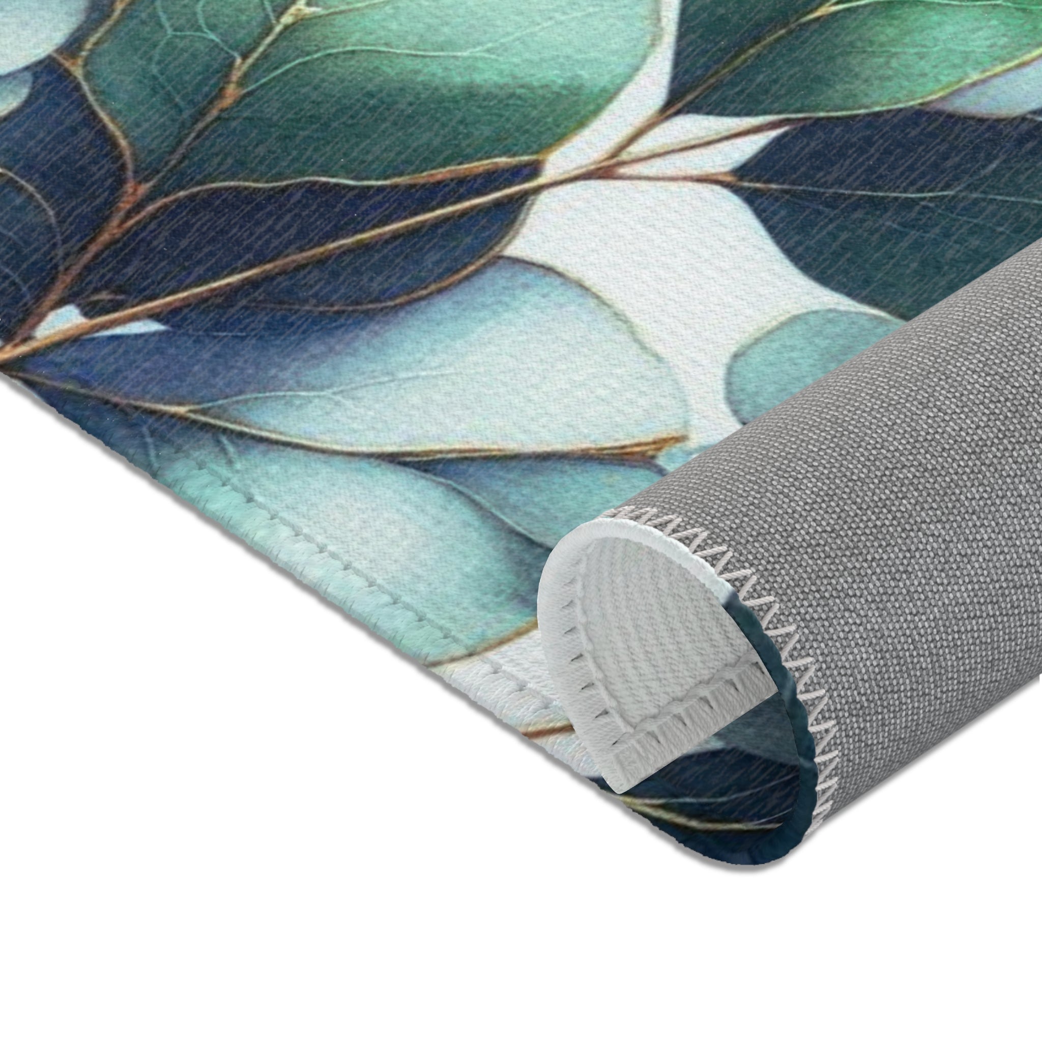 a close-up view of a rug with a leafy pattern in shades of green and blue.