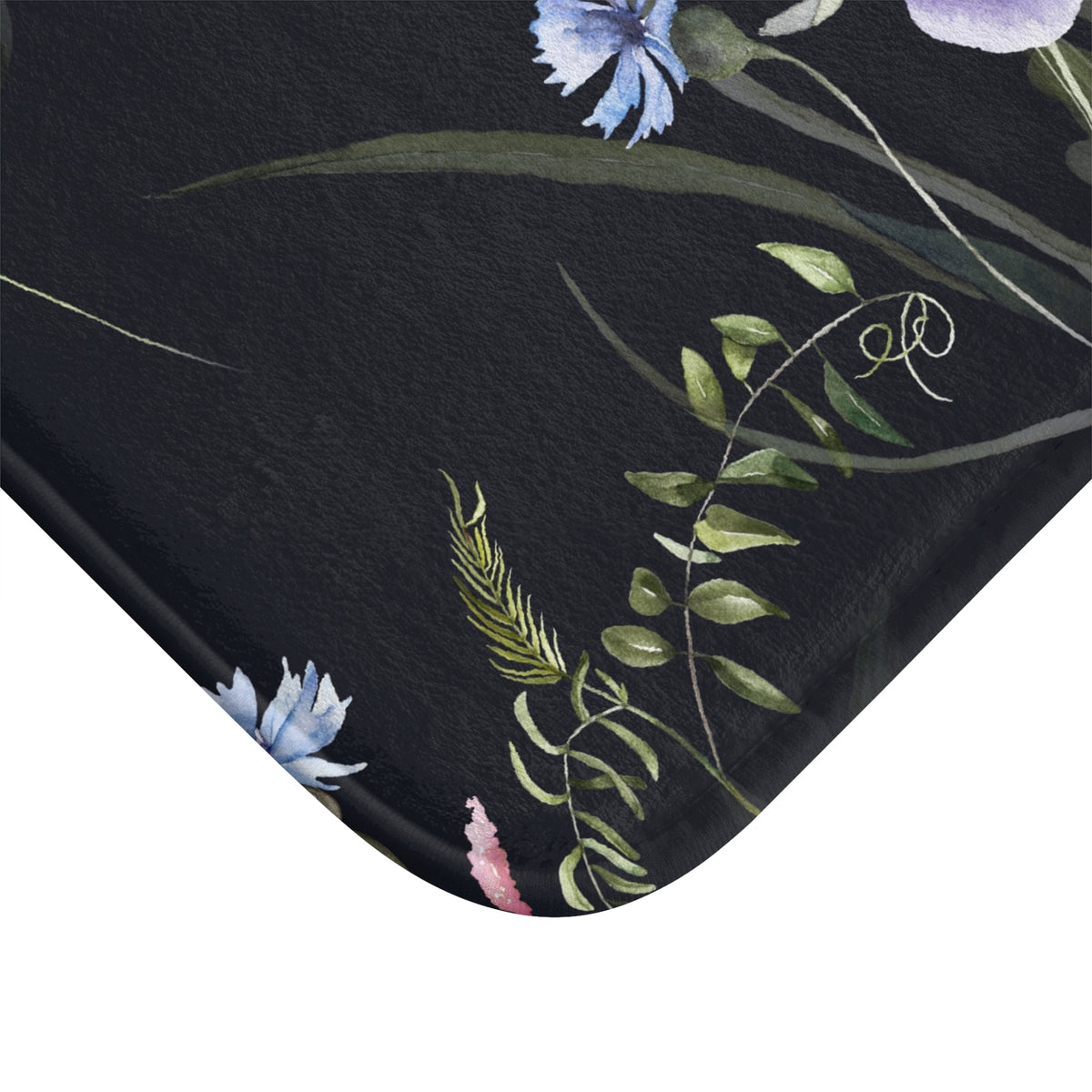 a close-up view of a black surface with a floral pattern, including blue and green flowers and green leaves.