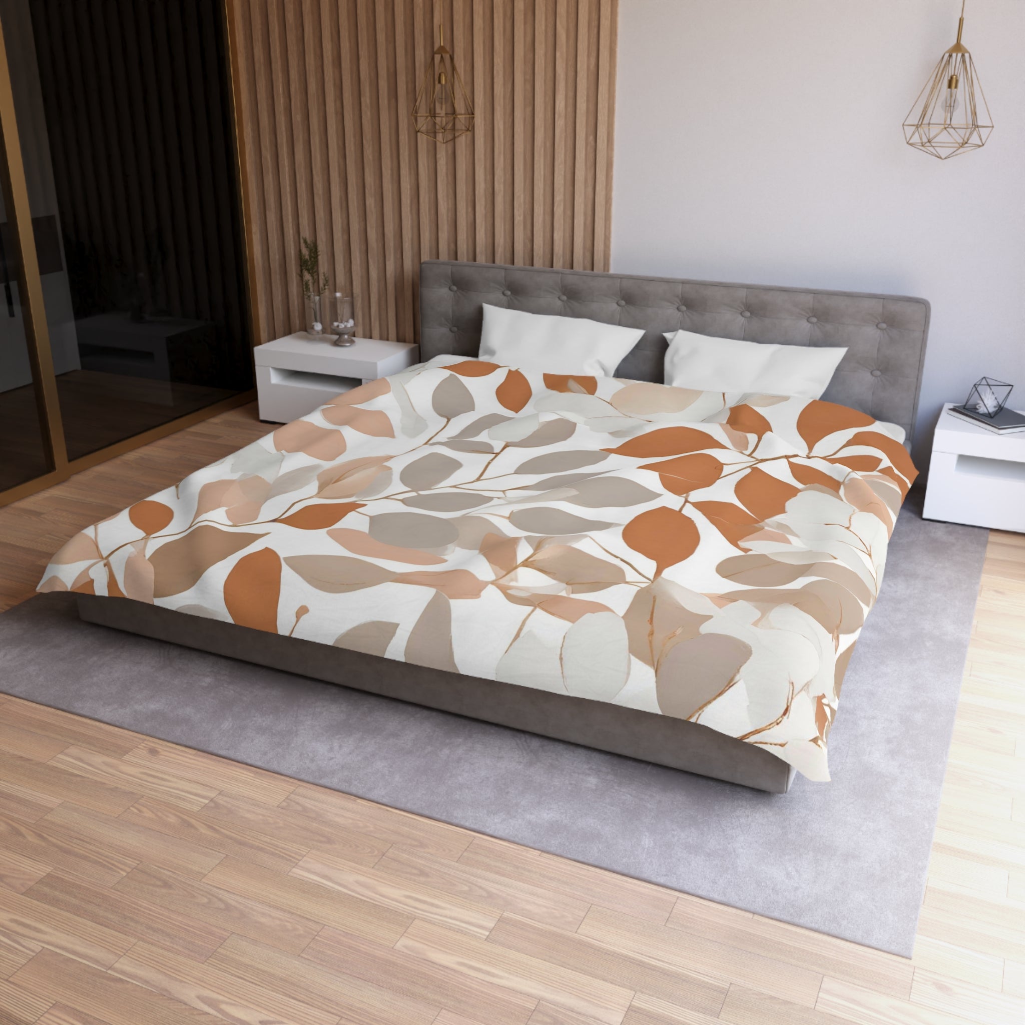 a modern bedroom with a large bed, a gray headboard, and a wooden wall. The bed is covered in a comforter with a leaf pattern in shades of brown and orange. There are two white nightstands on either side of the bed, and a gray area rug is placed in front of the bed.