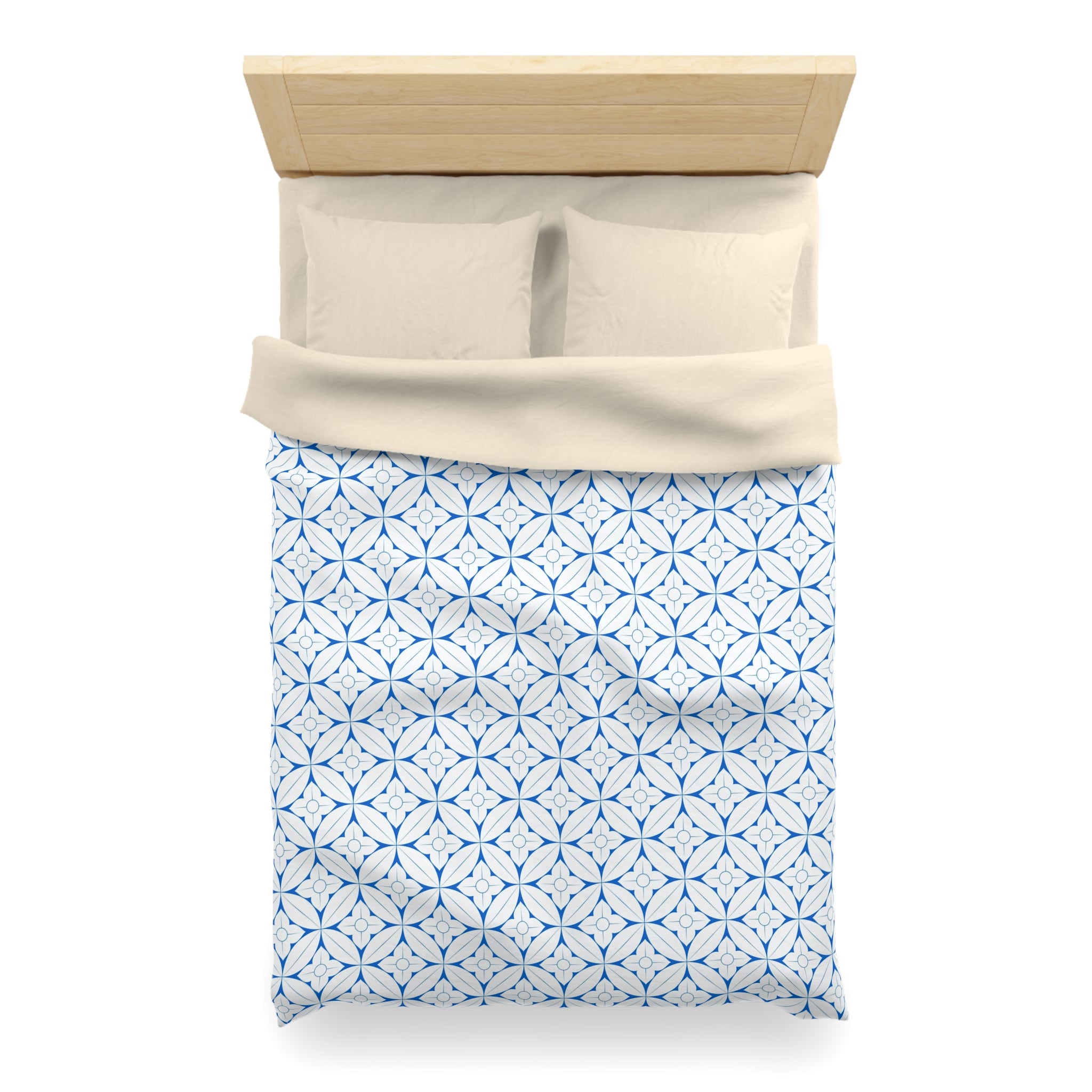 A neatly made bed with a blue and white patterned comforter and pillows.