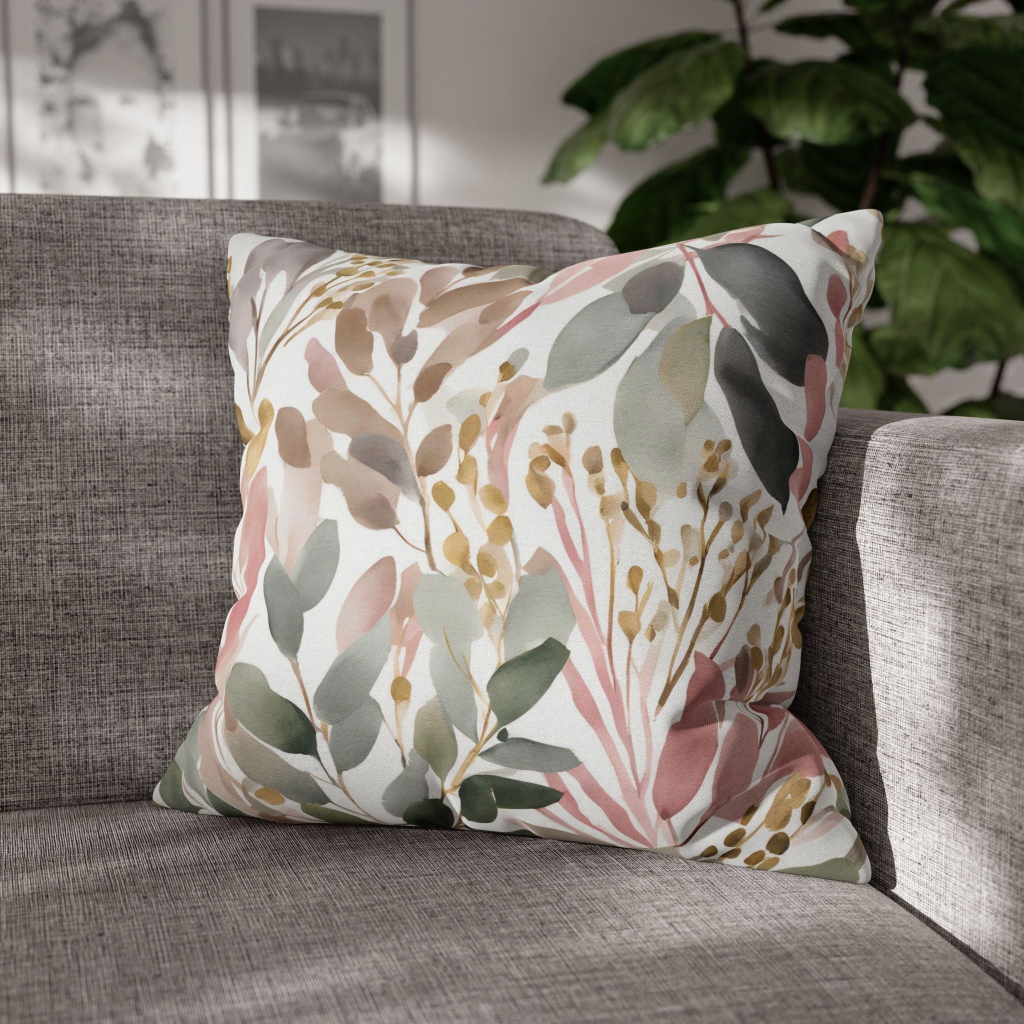 A gray sofa with a decorative throw pillow featuring a floral pattern in shades of pink, green, and brown.