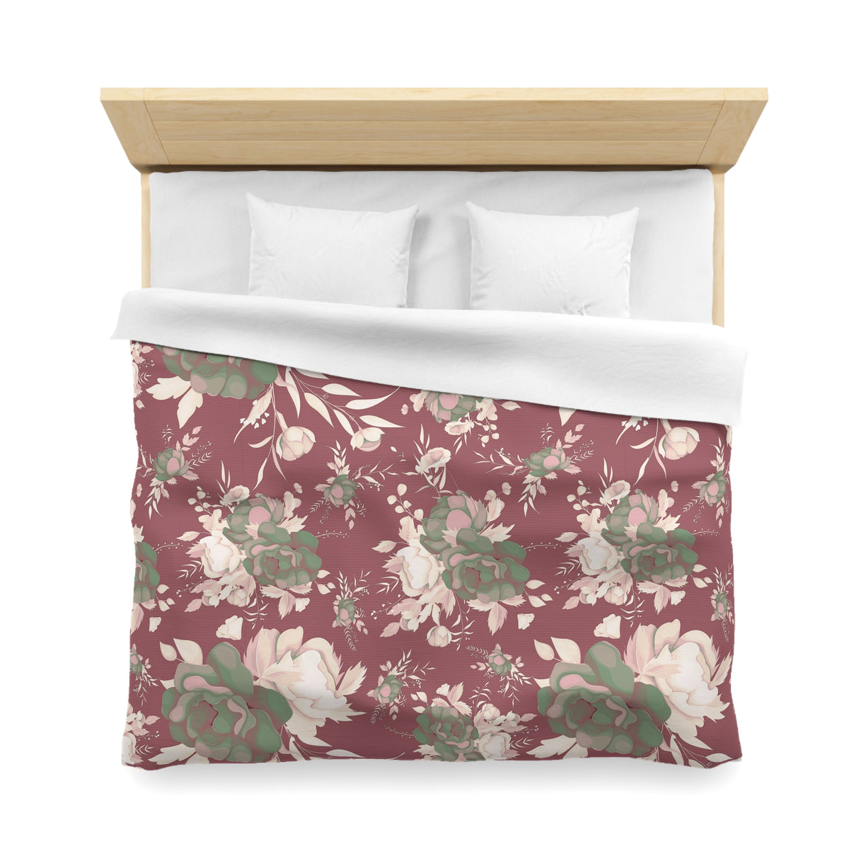 a bed with a floral patterned comforter and pillows.