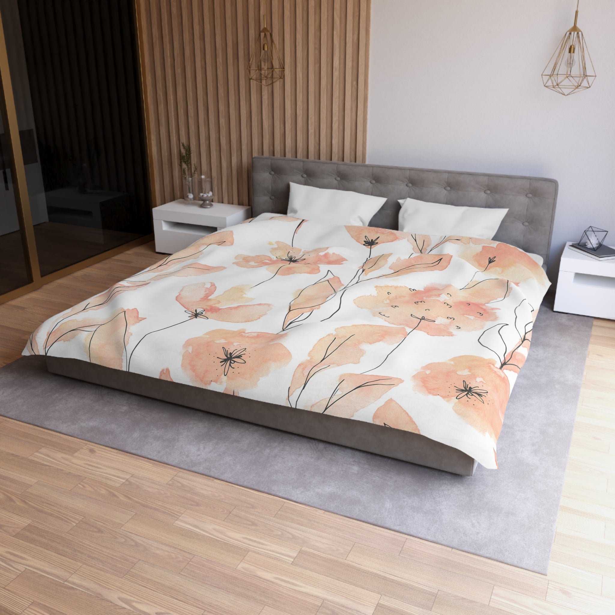 a modern bedroom with a large bed covered in a floral print comforter. The bed is positioned against a wall with a wooden panel. The room has a gray headboard and a white nightstand on each side of the bed. The floor is covered with a gray rug, and there are two pendant lights hanging above the bed.