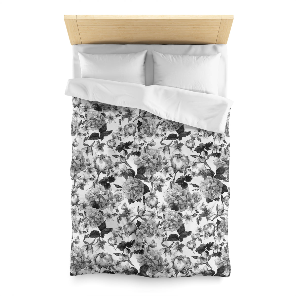 a neatly made bed with a floral print duvet cover and two white pillows.
