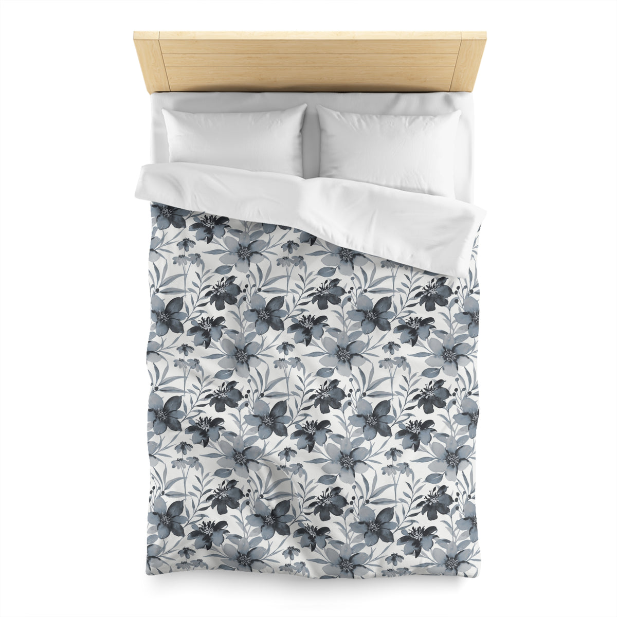 a neatly made bed with a floral patterned comforter and pillows.