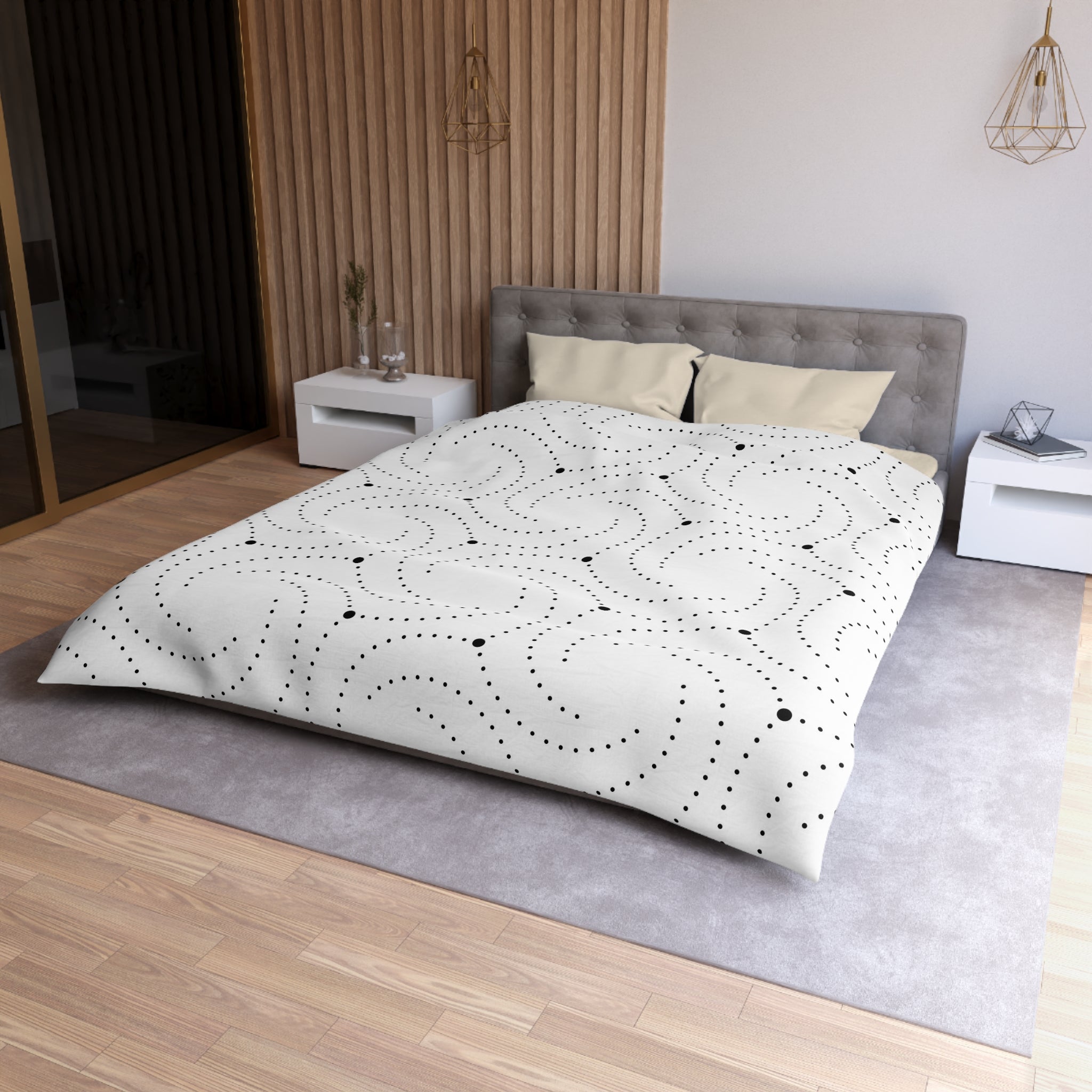 a modern bedroom with a large bed, a gray headboard, and a white bedspread with a black and white dotted pattern. The room has a wooden floor and white walls, creating a clean and minimalist aesthetic.