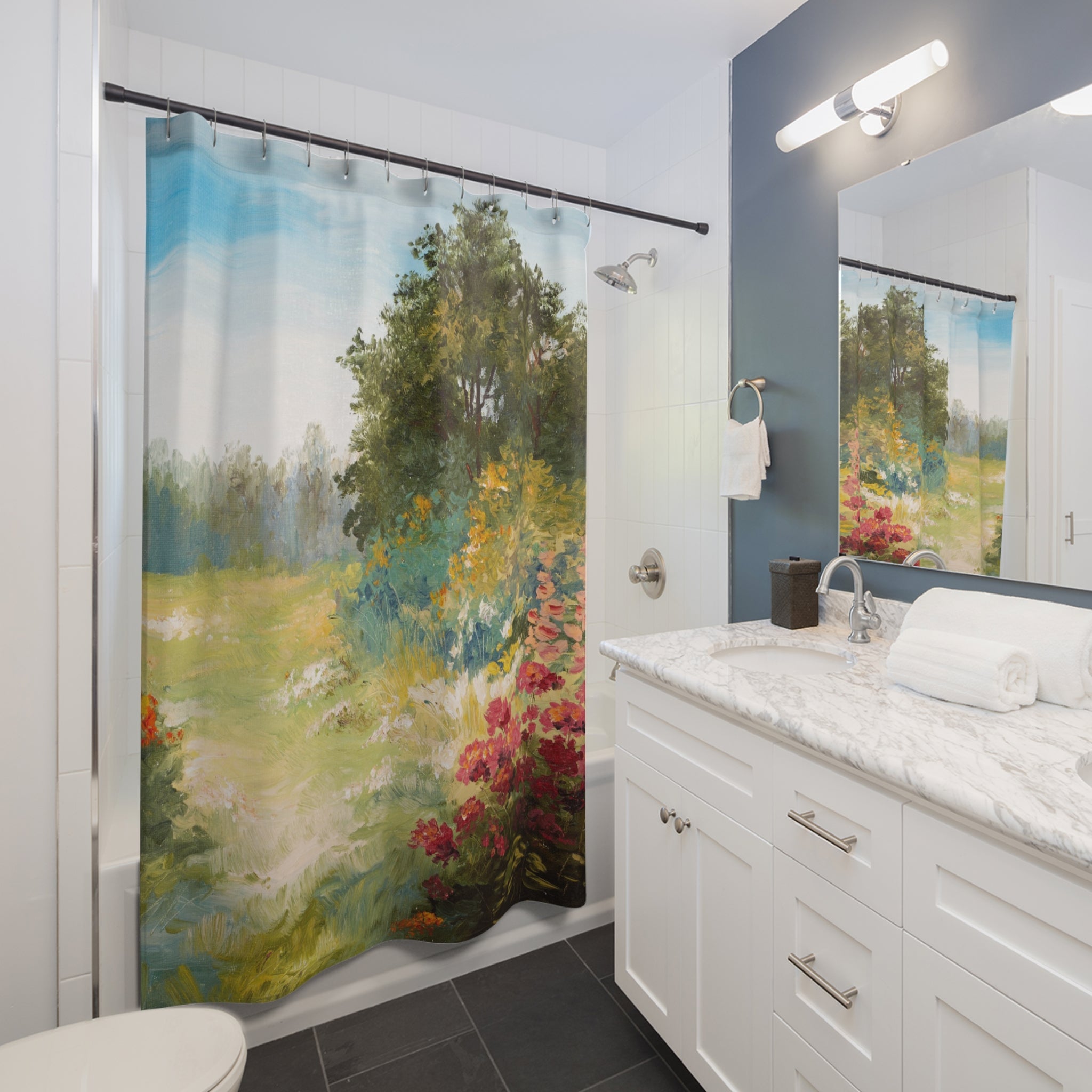 a bathroom with a shower curtain featuring a landscape scene, including trees, flowers, and a grassy field. The bathroom has a white vanity with a marble countertop and a mirror above it.