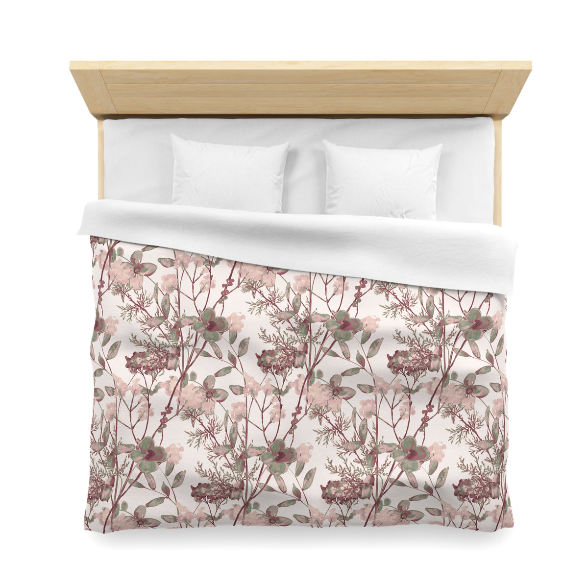a neatly made bed with a floral print comforter and two white pillows.